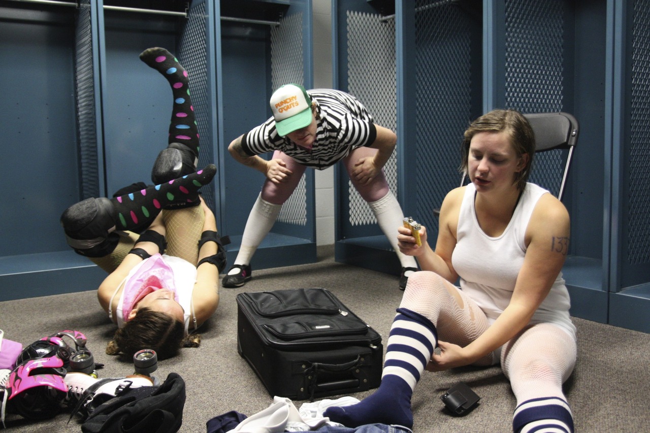 Punchy O' Guts and her teammates stretch and chug whiskey after a roller derby bout in Portland, Maine. Roller Derby is a contact sport played by two teams where five members skate around the track in the same direction. The teams score points, when the jammer (a designated scorer) laps members on the opposing team.
