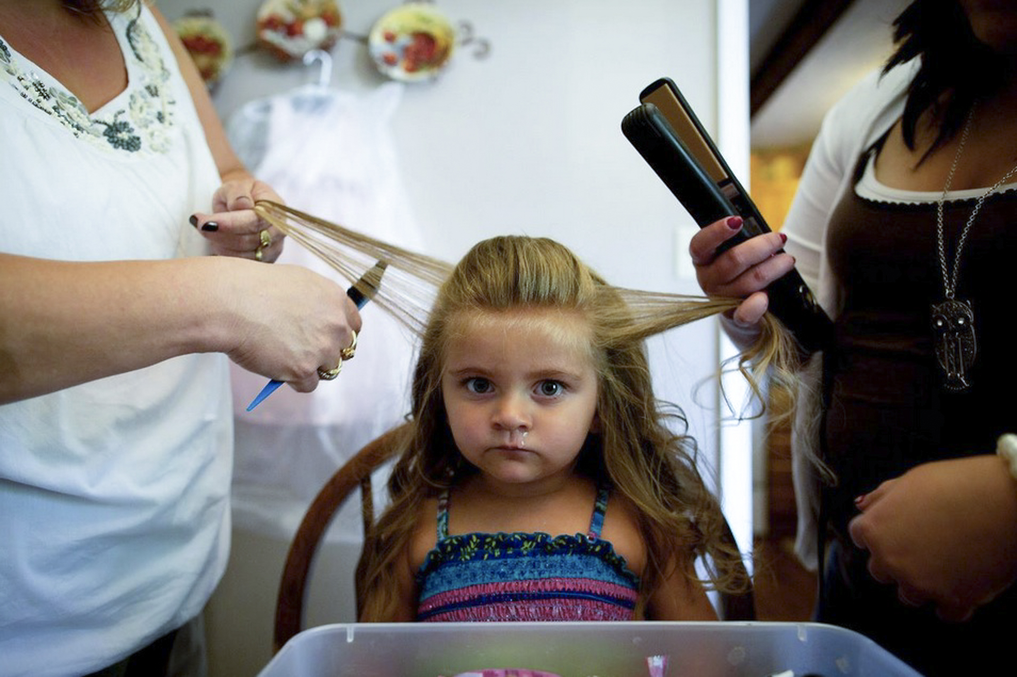 JayCee Jarrell, 3, puts up a fight as her mom and mawmaw get her ready to compete in the Coal Festival Beauty Pageant. After spending most of the night shopping in Walmart to get beauty supplies, JayCee just wants to go back to sleep.