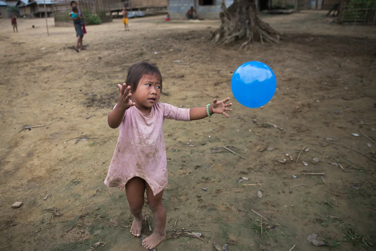  A child sees and plays with a balloon for the first time in the Mok Dou village, in rural Laos. 
