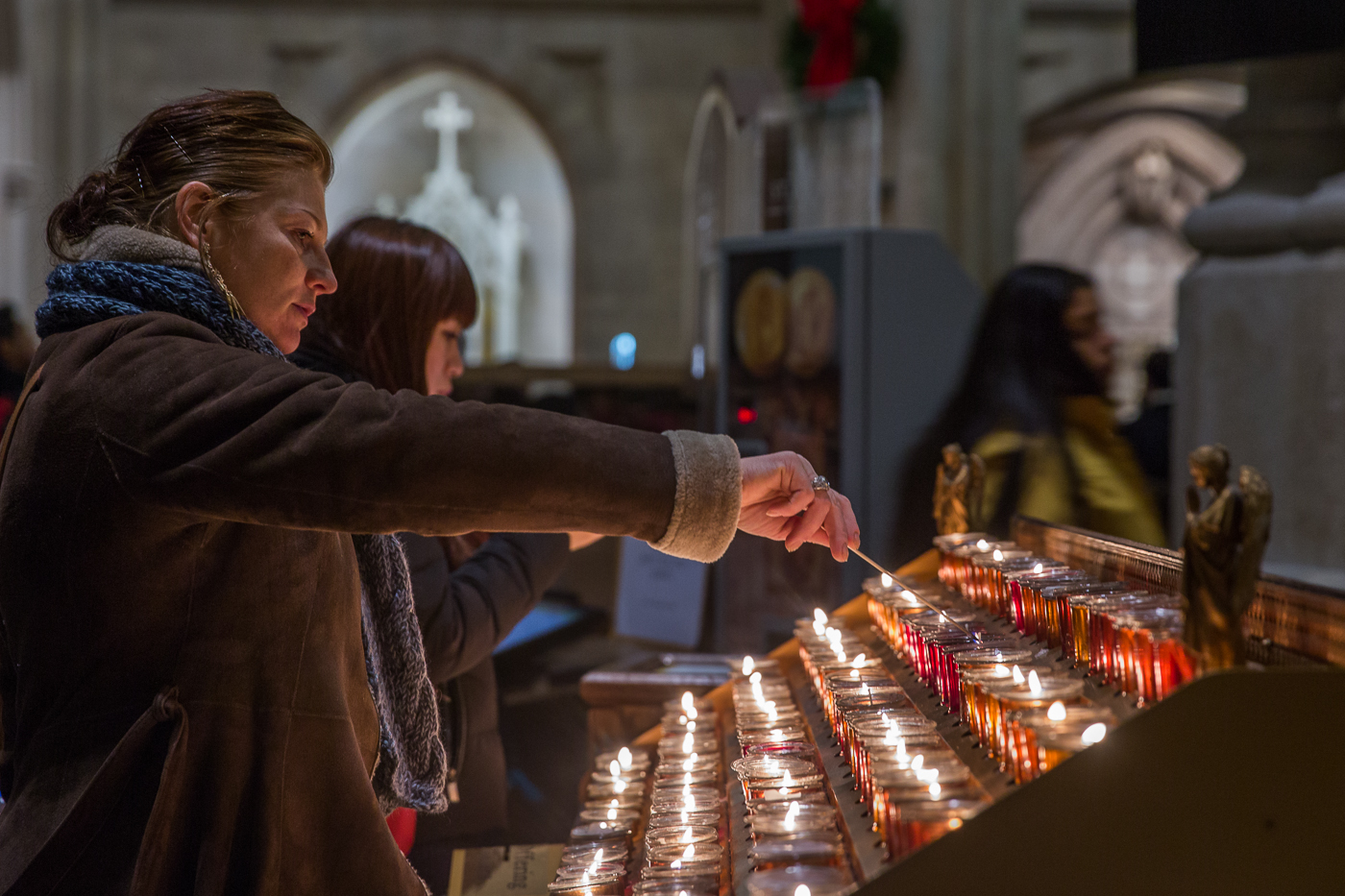 A woman lights a prayer candle at St. Patricks Cathedral in New York City on Christmas Day, 2014. St. Patricks Cathedral recevies over five million visitors from around the world each year, and over a million candles are lit as an act of prayer. 