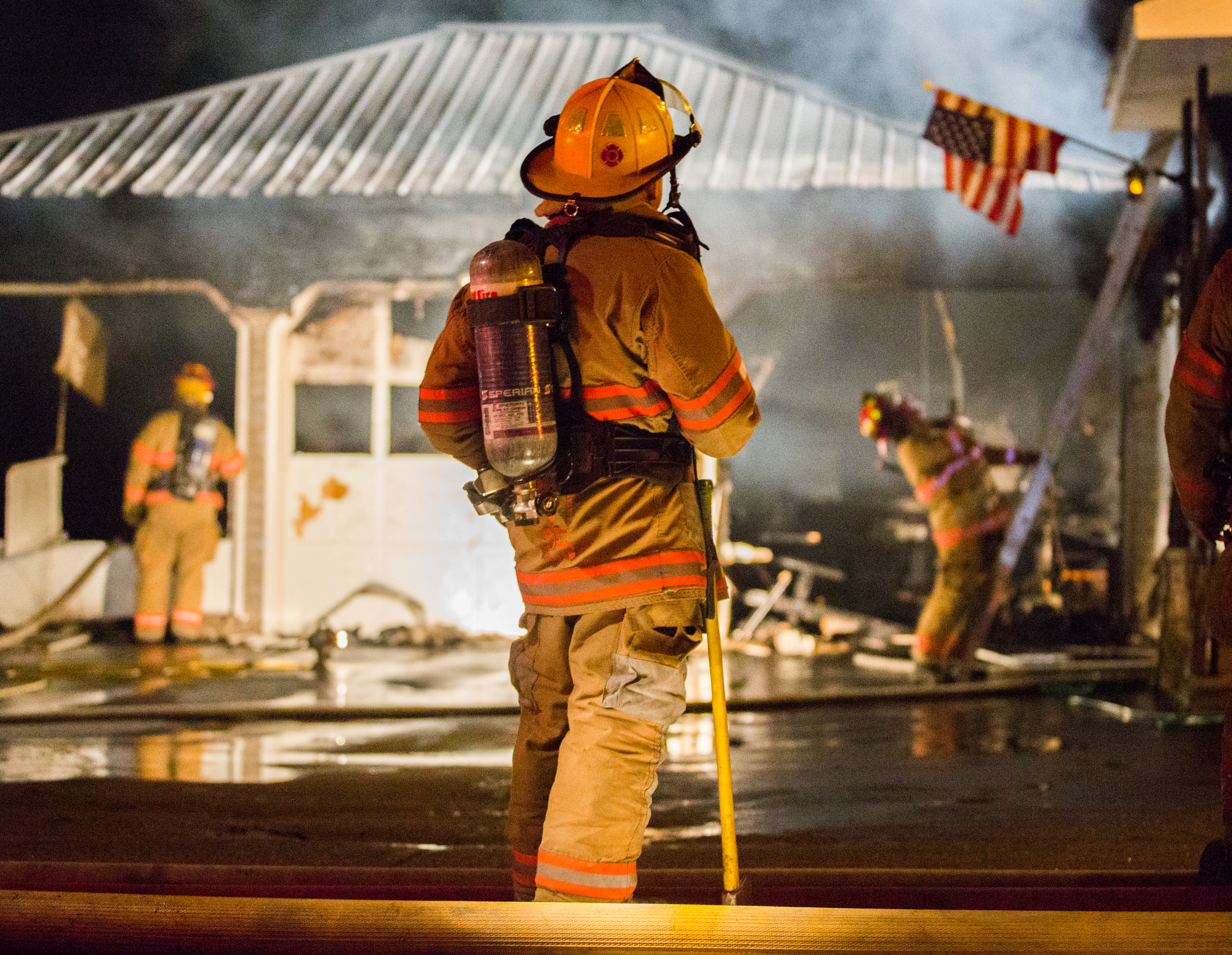 Firefighters work at the scene of a garage fire caused by the improper disposal of bonfire ashes, in Lewiston, Maine on Monday May 5th. 