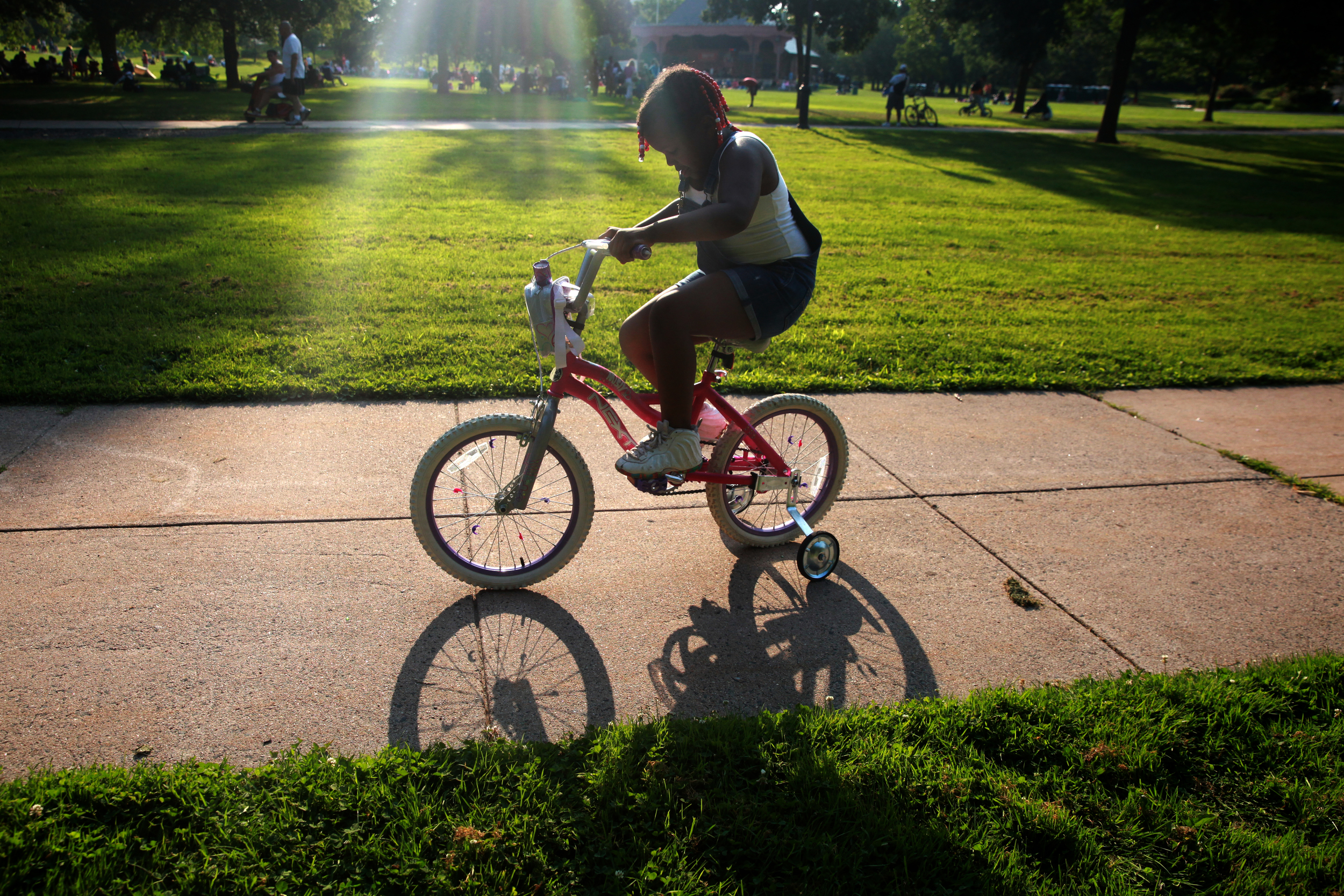 Amiyah Austin, 6, of Hartford rides her bike with her cousins in Bushnell Park during the parks Monday night Jazz series. 