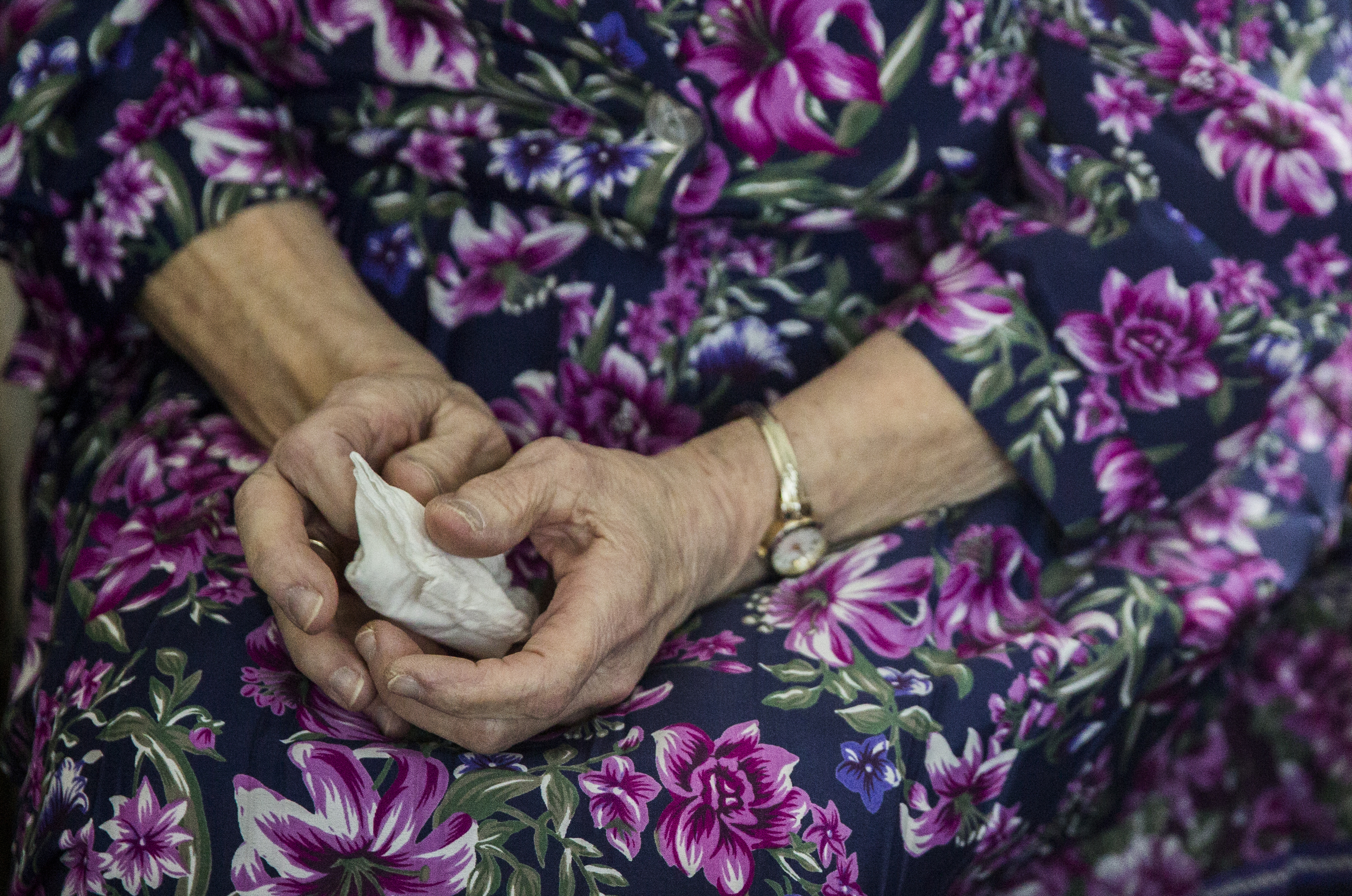 June Weeks holds a tissue in her hand in case she cries, as she watches her husband Clayton Weeks, a veteran, receive an award thanking him for his service in their mobile home in Mexico, Maine. 