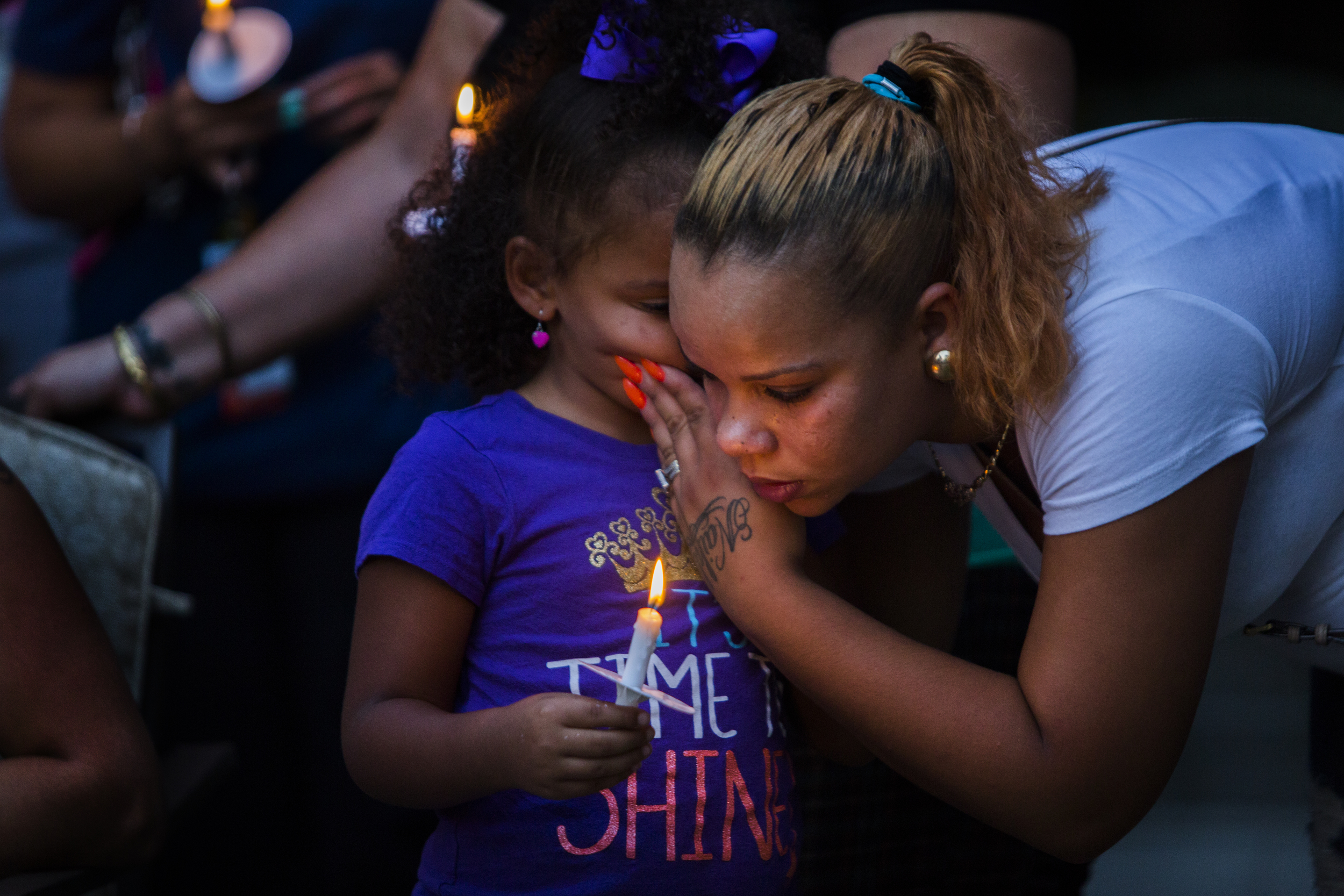 Ominaihly Flores, 4, whispers into her mother's, Kati Lopez's ear at a vigil held for William Prieto, 32, who was shot and killed while sitting on his porch in Hartford, CT on August 31st. Prieto was the 23rd homicide in Hartford in 2015. 