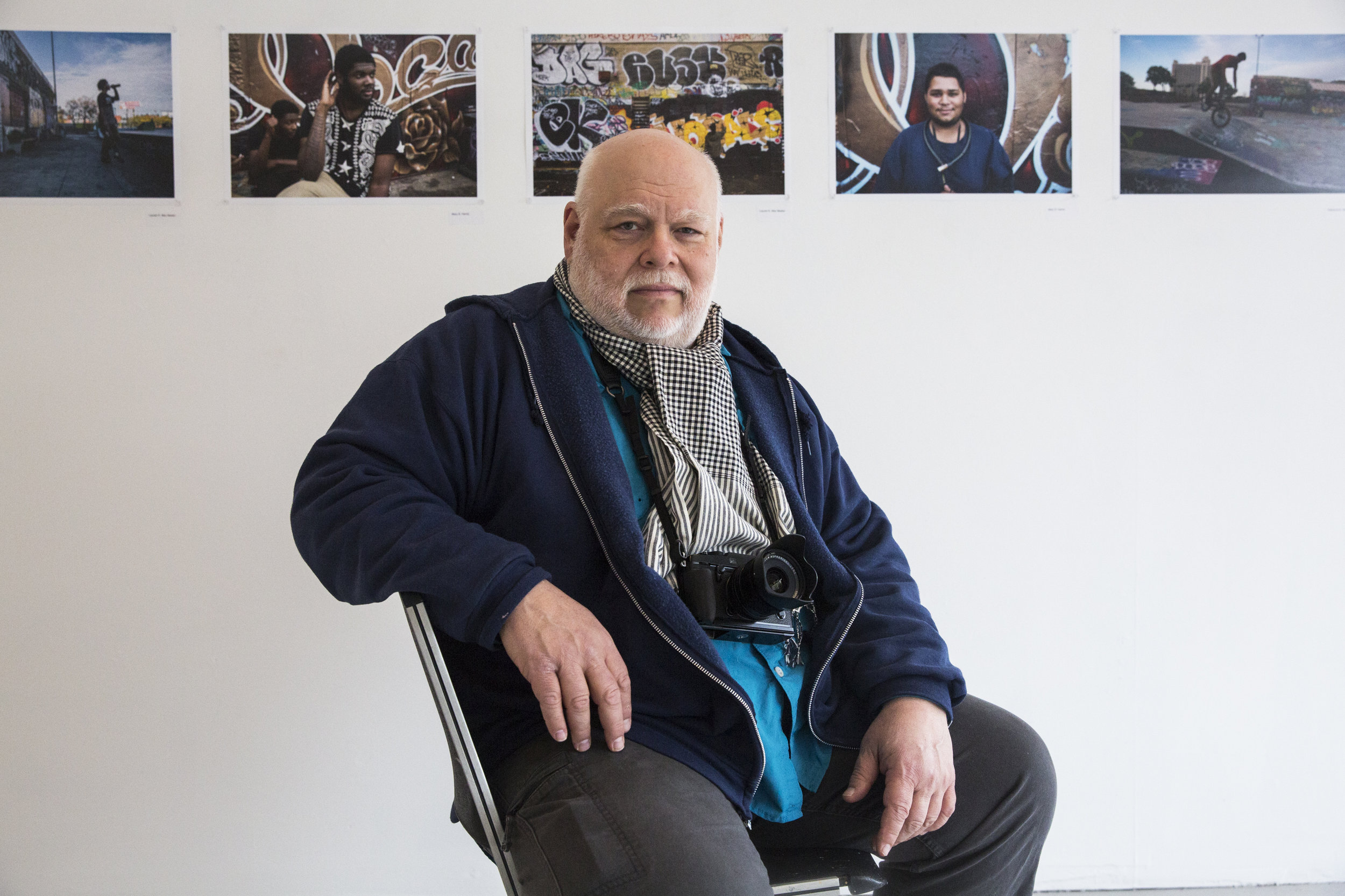 Photographer and Trinity Professor of Fine Arts Pablo Delano, sits in Trinity College's Broad Street Gallery in front of photographs from his freshman seminar called "Photographing Hartford; Our City." Delano is teaching his students to use the camera as a tool for research and discovery and as a way to get to know the city of Hartford. 