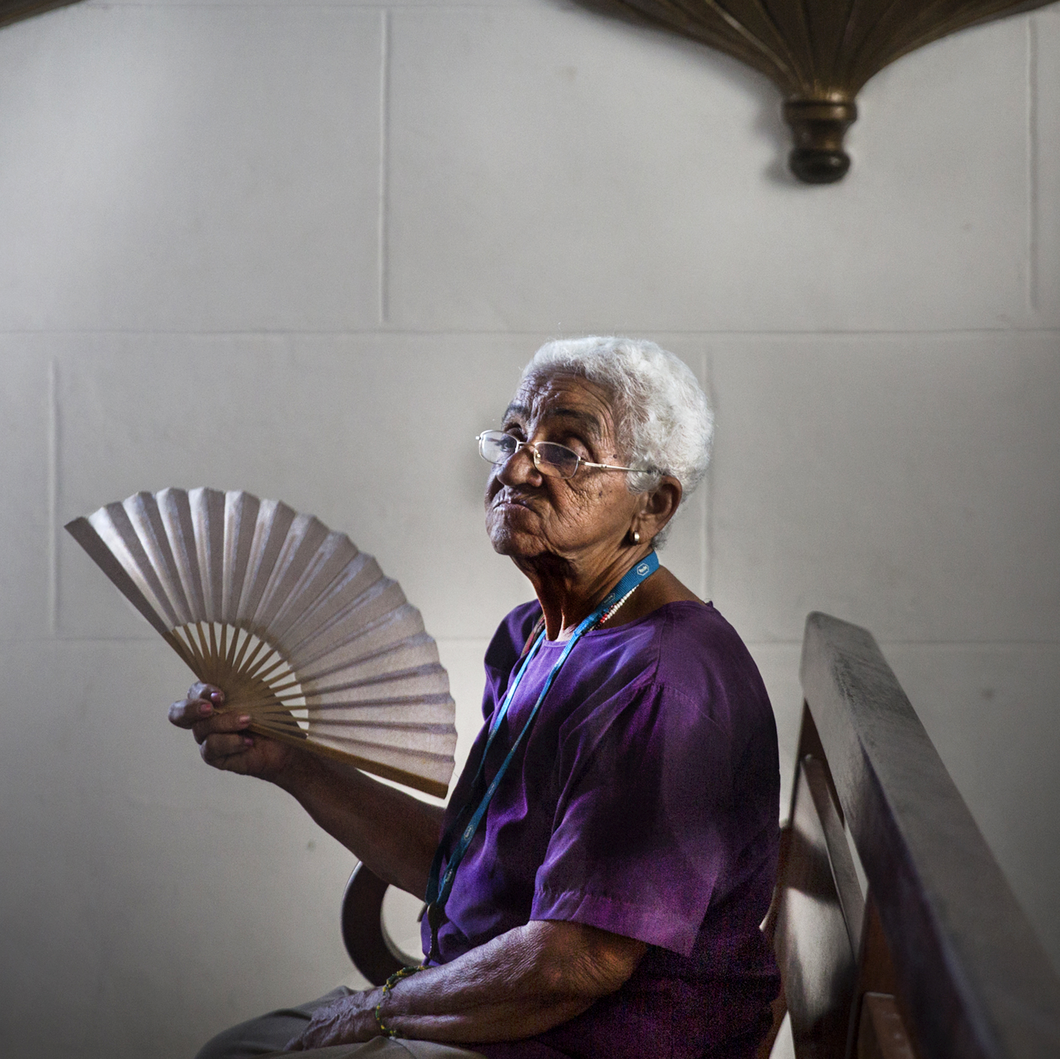 A woman fans herself inside a church in Regla, Regla is one of the 15 municipalities or boroughs in the city of Havana, Cuba. 