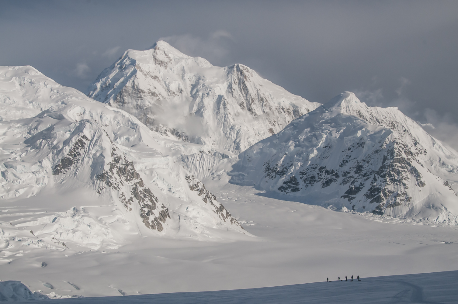 A rope team heads down Ski Hill on the Kahiltna Glacier, with Mount Hunter in the background.