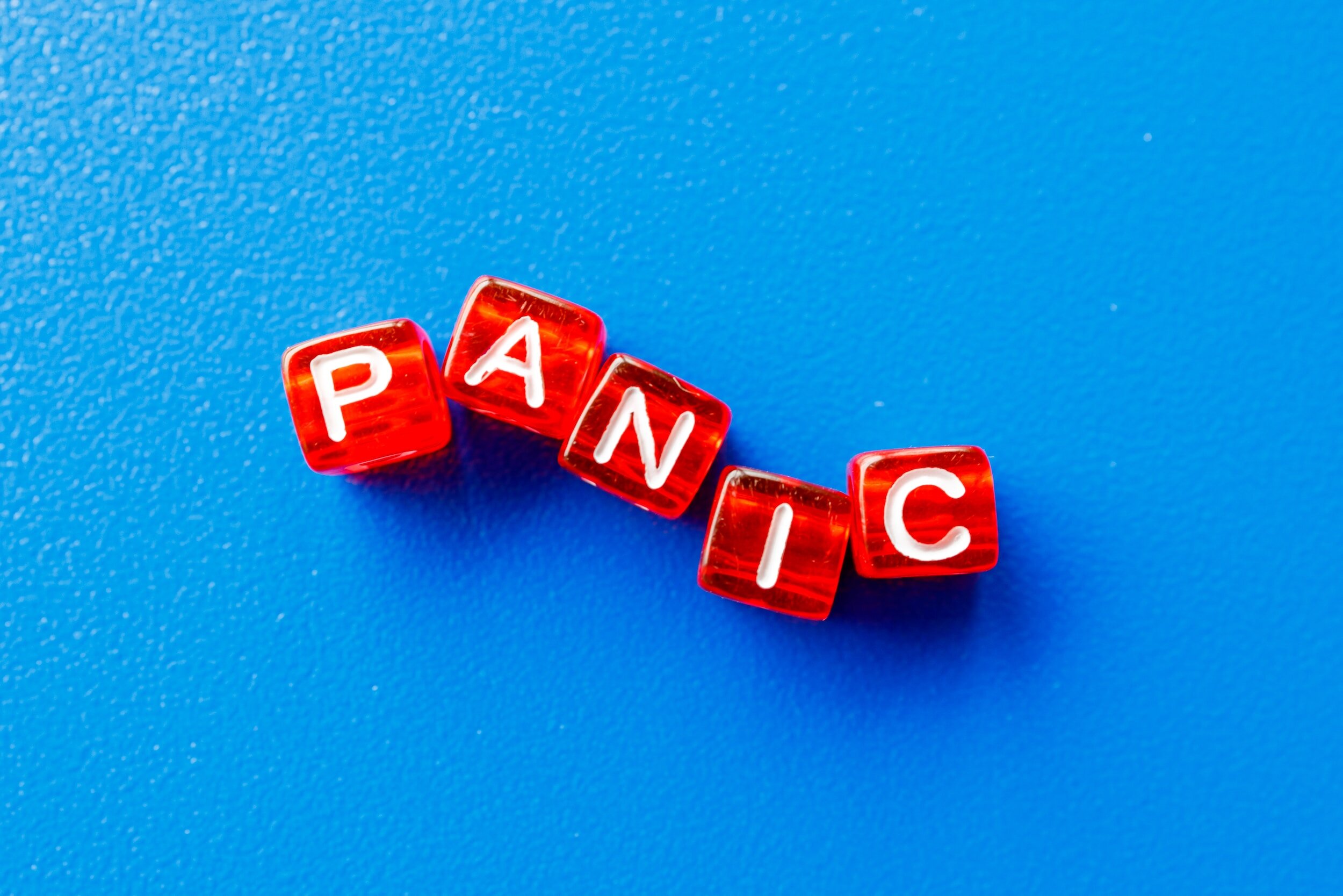 dice with letters printed on them spelling the word "panic"