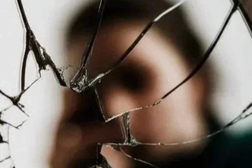 CBT for Trauma and PTSD: A blurred image of a woman looking into a shattered mirror
