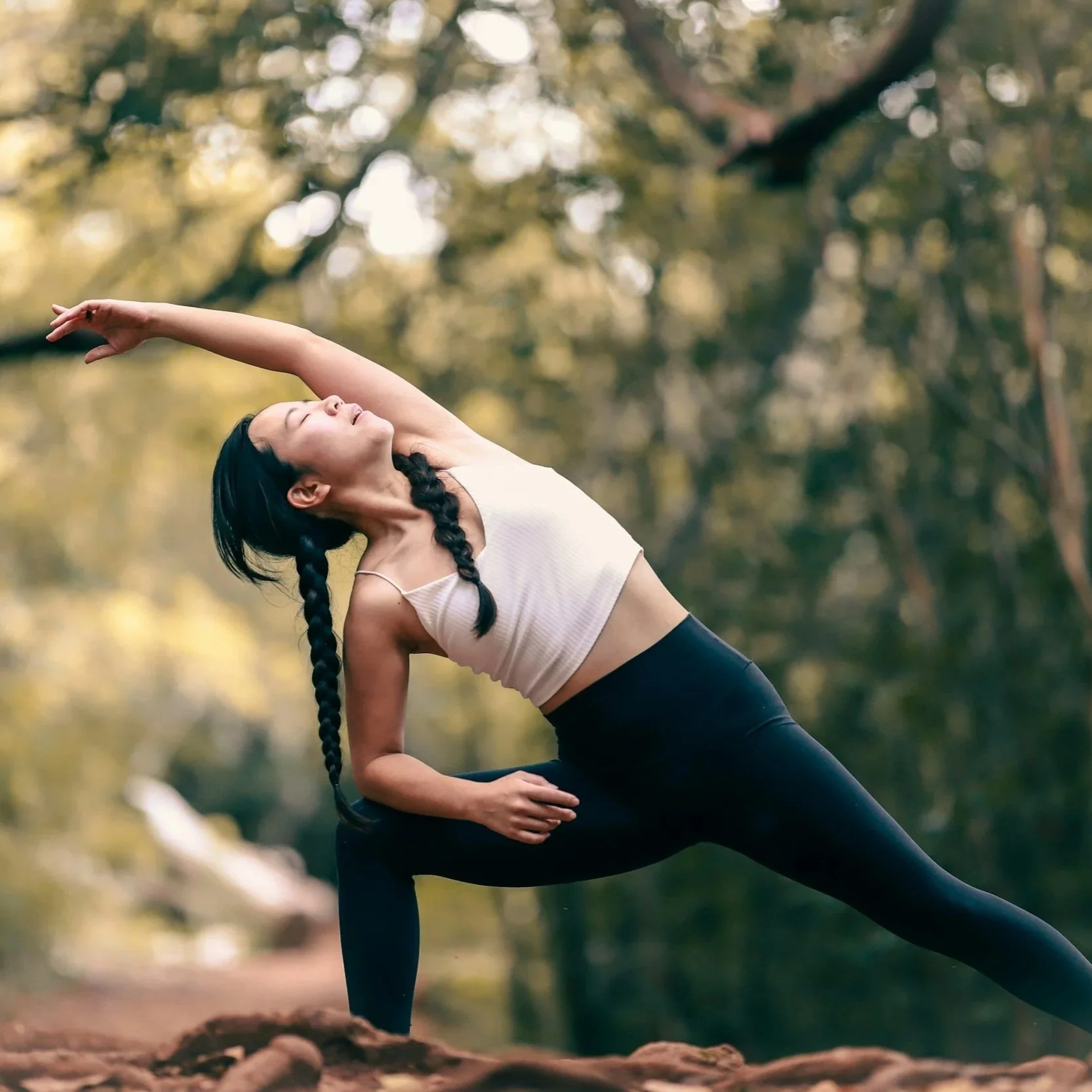 A woman performs a yoga pose outdoors