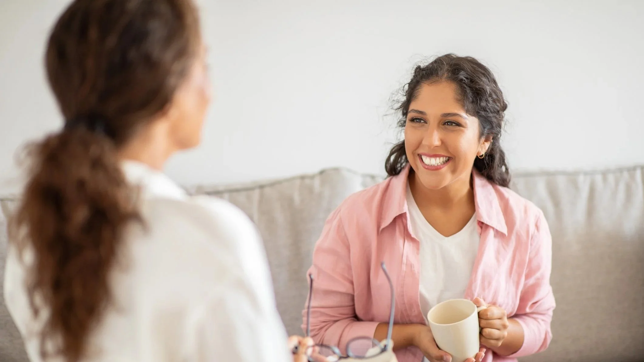 CBT Therapy Session: Woman beams as therapist talks to her