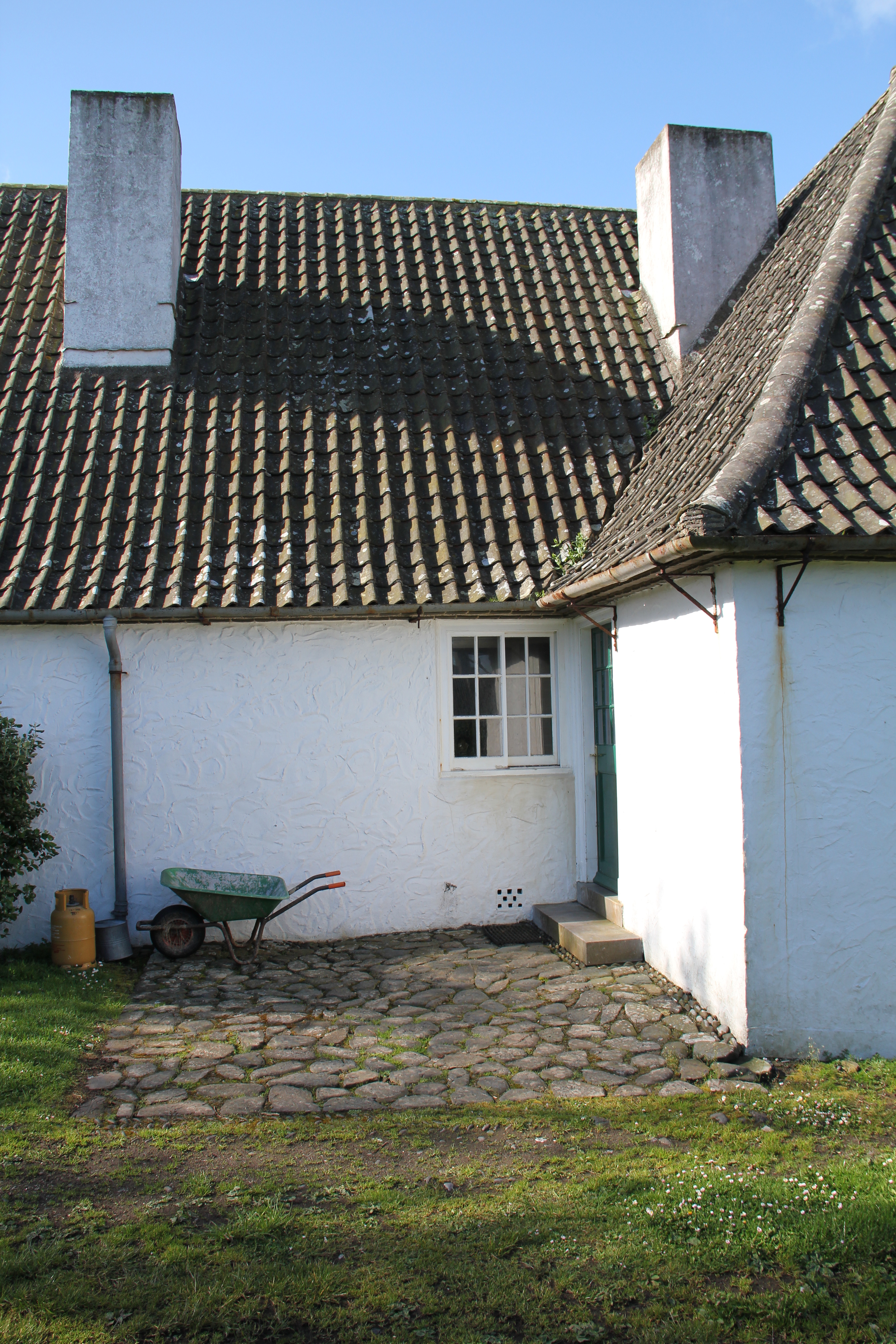 Close to the harbour is the White House, a largely single-storey horse-shoe shaped house with high roofs and white harled walls