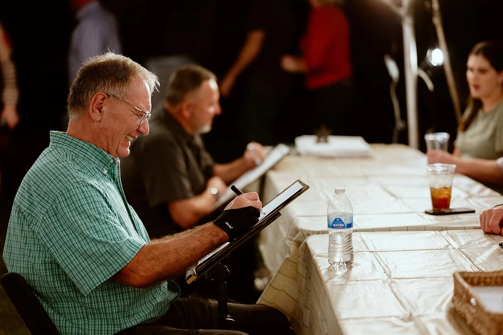 Man sketching at an event table with others
