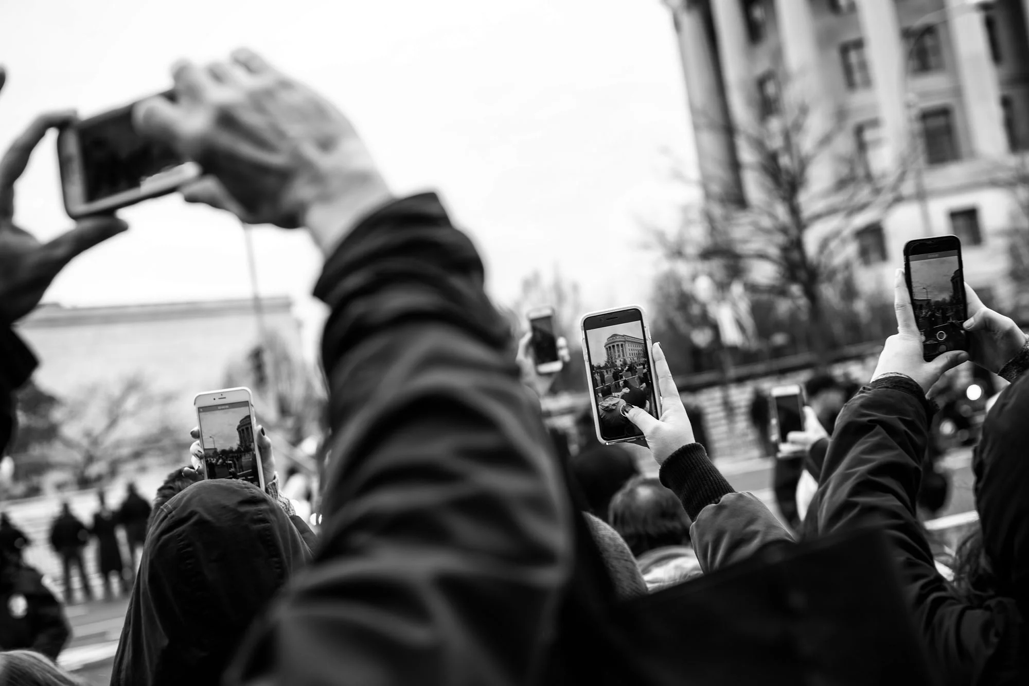 Attendees try to capture a glimpse of the President-elect arriving along Pennsylvania Avenue prior to the Presidential Inauguration in Washington, DC on January 20, 2017.