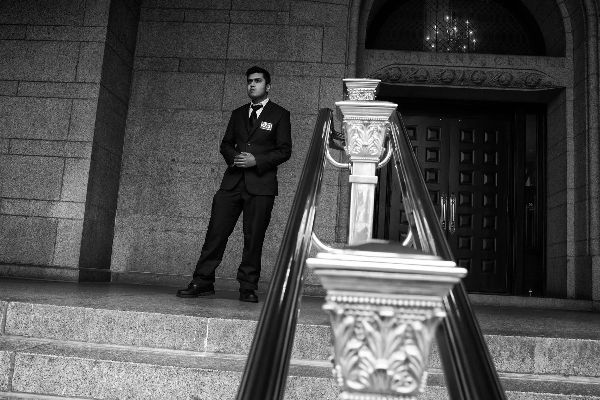 A security guard at the Trump hotel watches protesters after President Trump's executive order banning people from seven countries from entering the United States, on January 29, 2017.