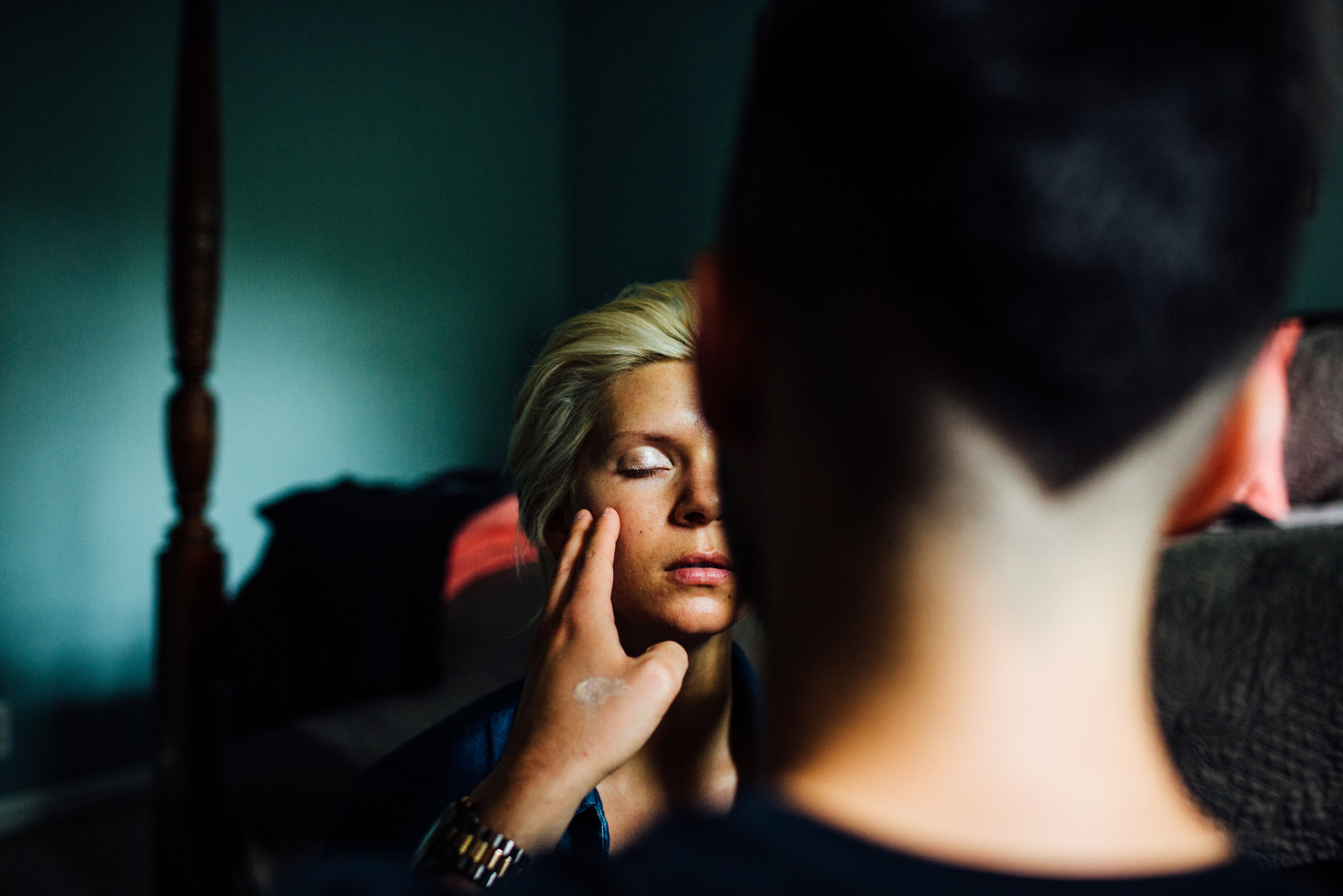 bride gets makeup done on wedding day