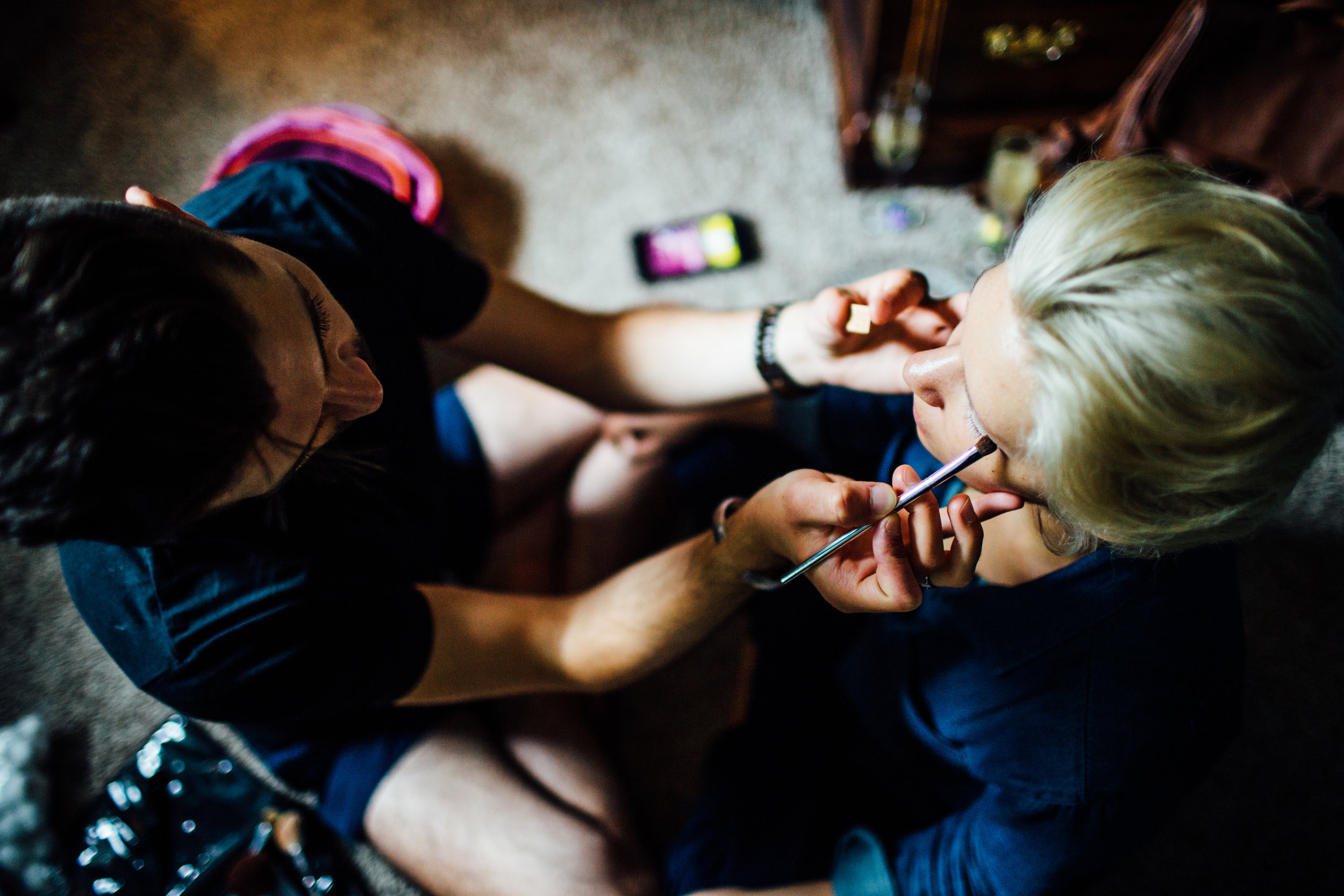 bride gets makeup done by make up artist