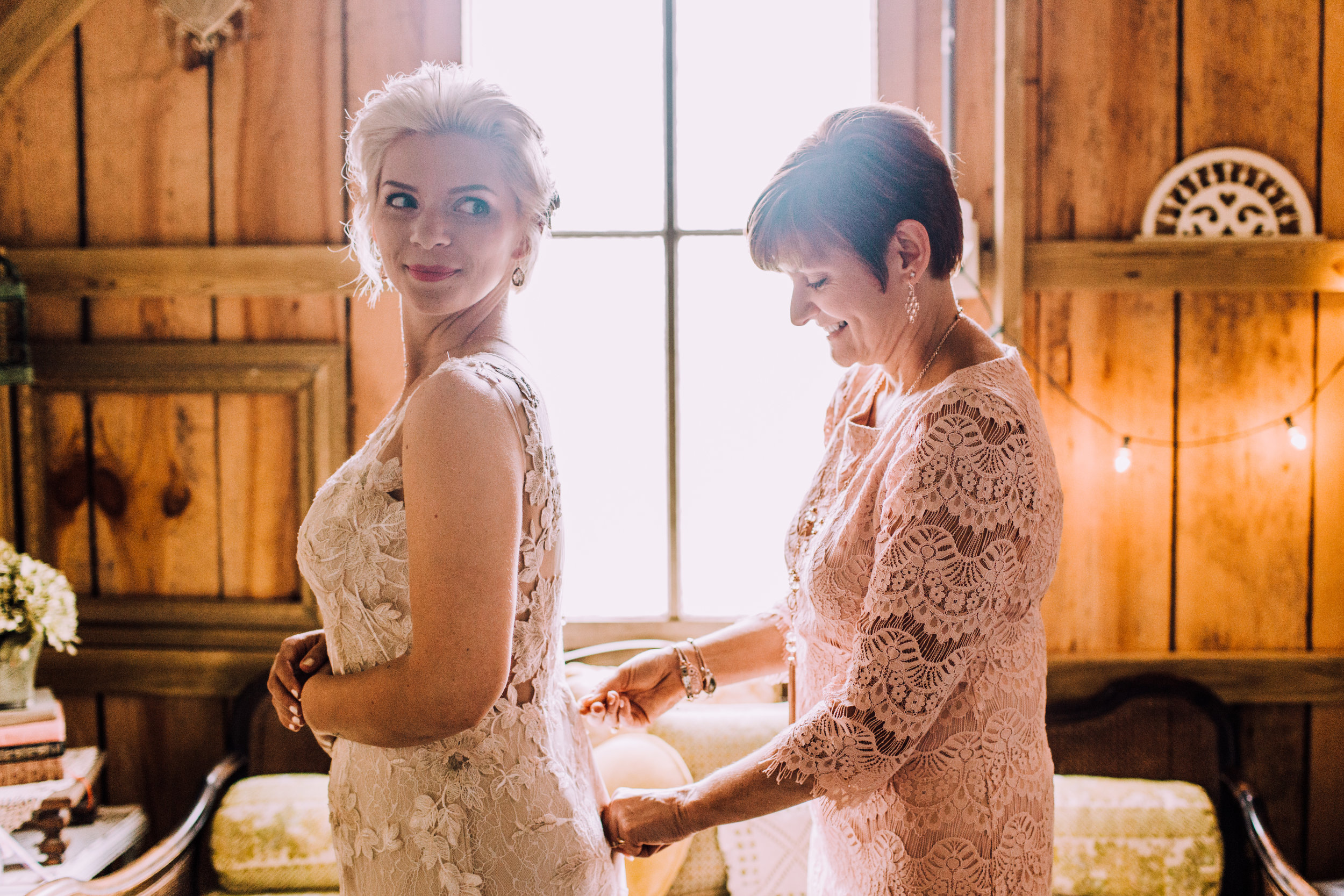 mom zips up daughter's wedding dress