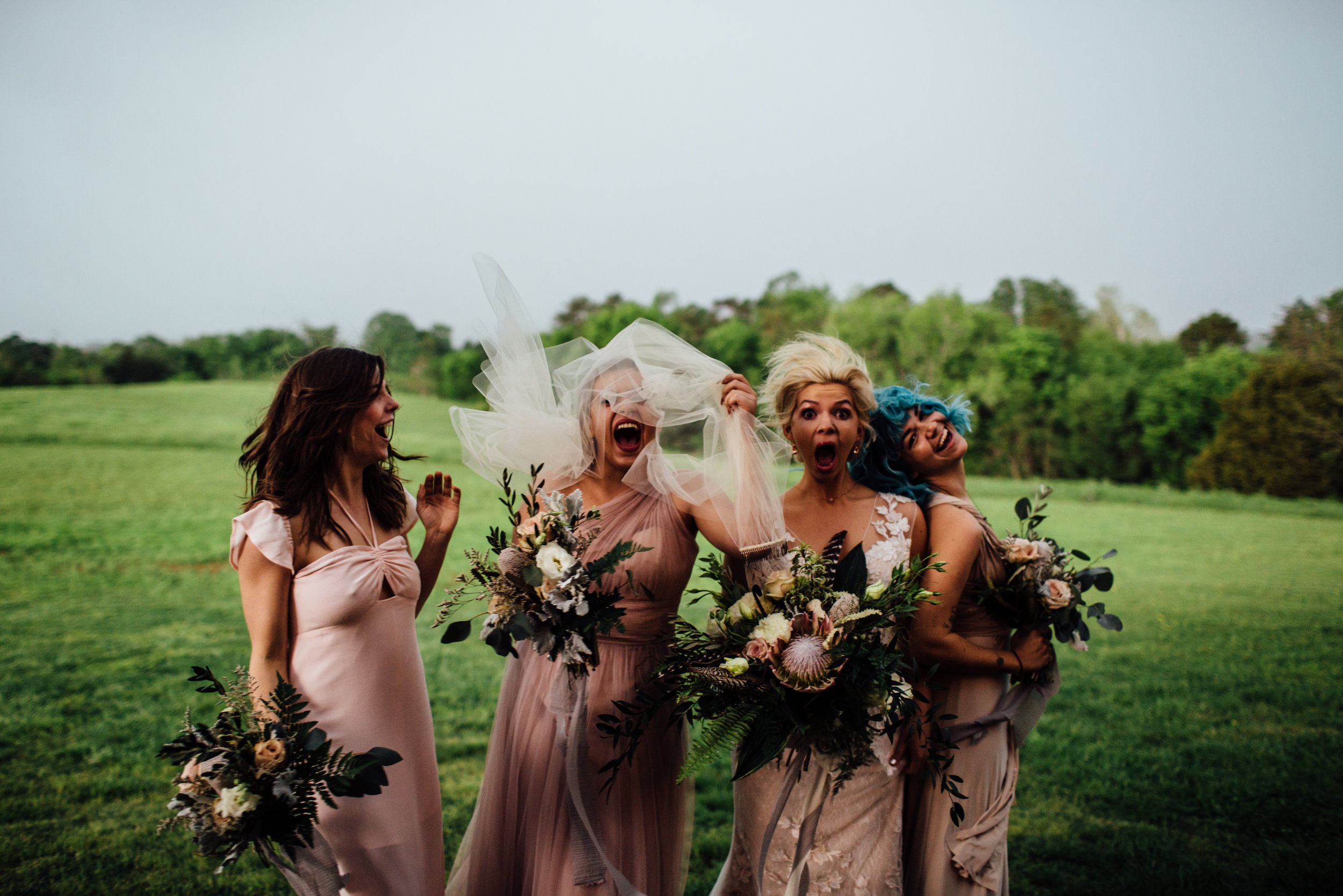 bride and bridesmaids surprised by the incoming windy storm