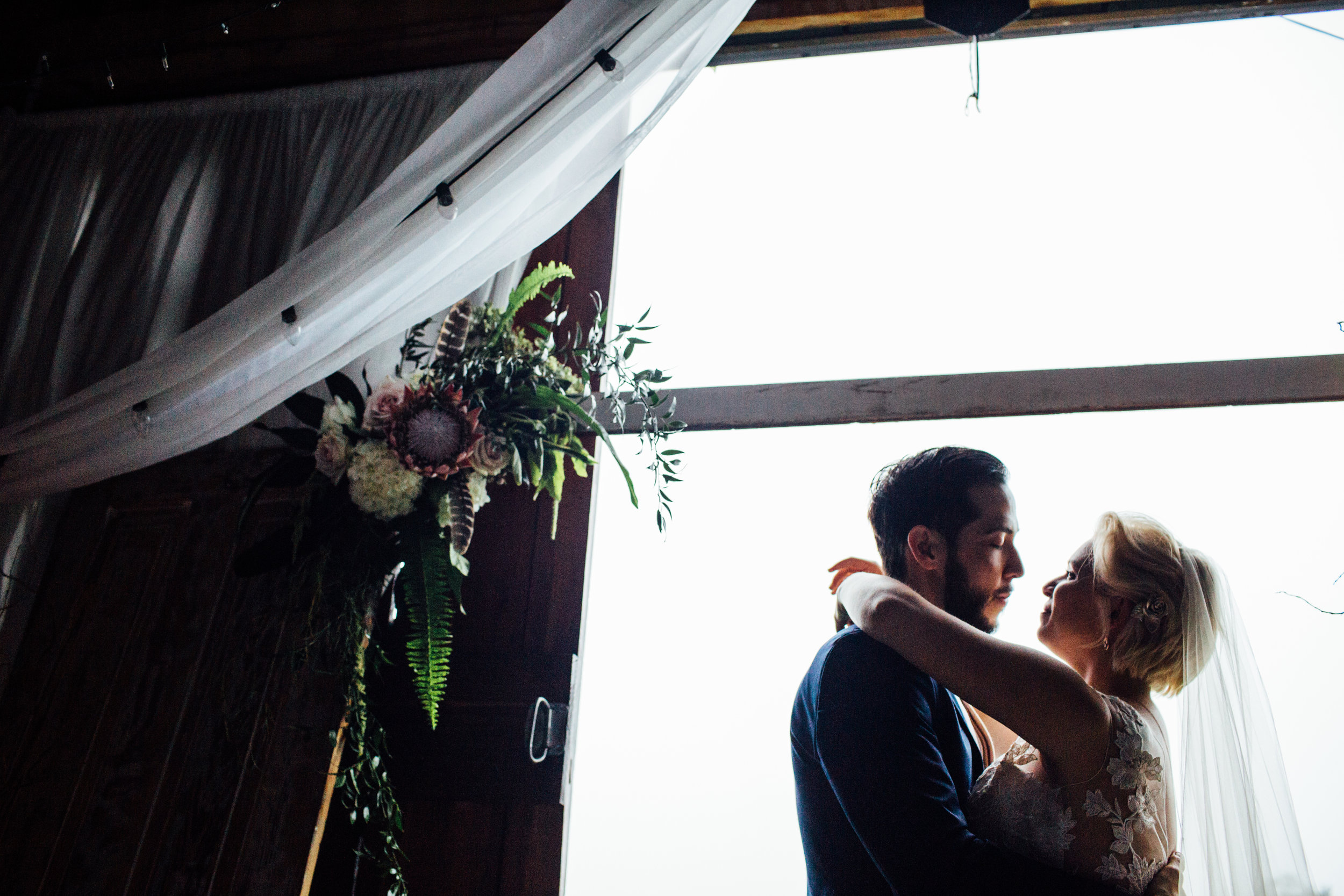 bride and groom silhouette inside barn