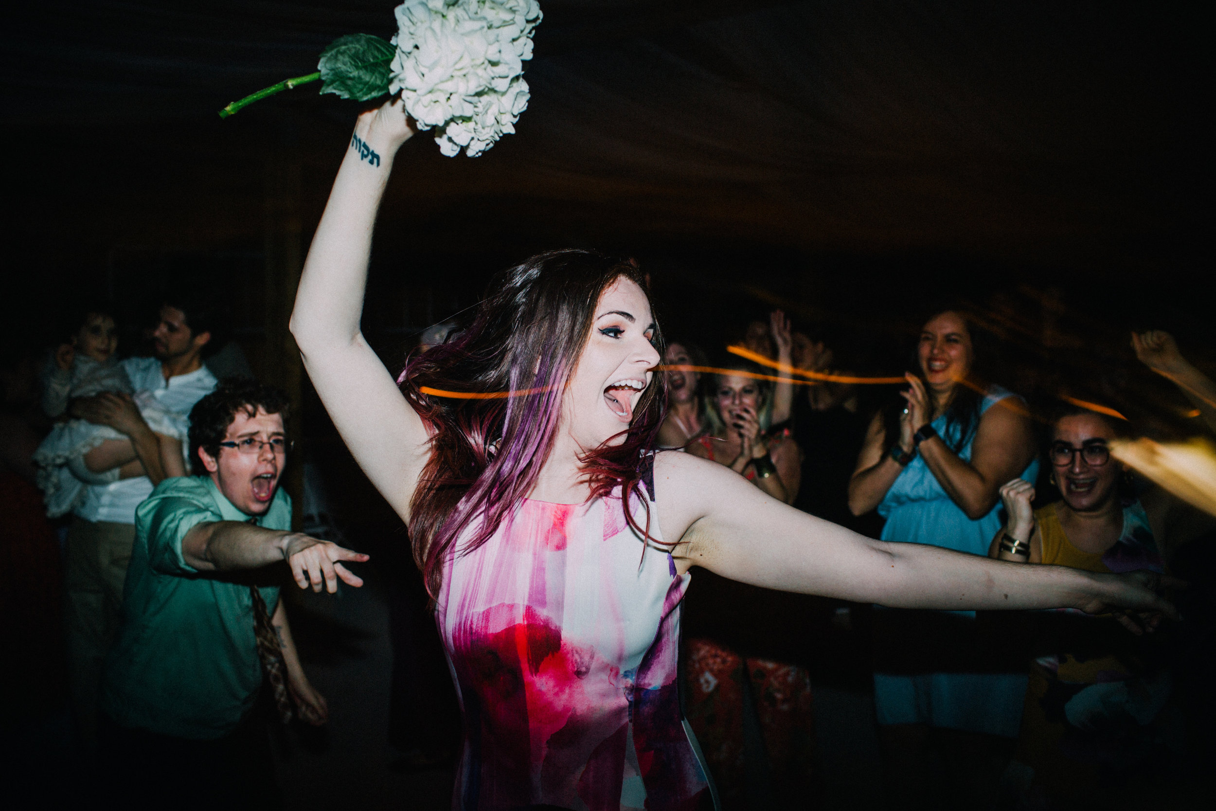 woman catches bouquet at reception
