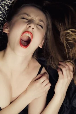 Woman screaming with sexual pleasure and ecstasy in bed