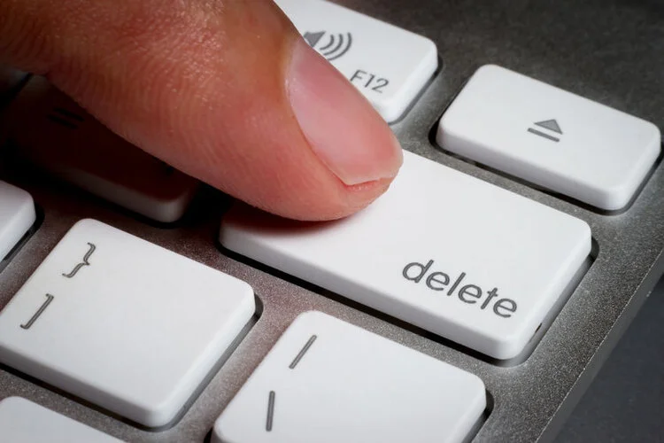 Pressing delete button on computer keyboard.