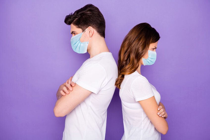 Couple wearing masks and fighting. Relationship conflict during COVID-19 pandemic.