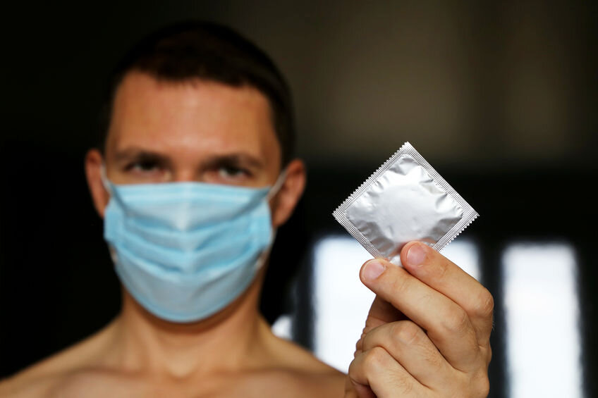 Mask and condom during COVID-19 pandemic. Coronavirus sex.