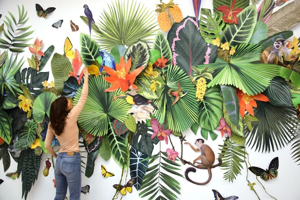 Guests engaging with a live botanical installation by Clare Celeste Börsch, created during an event as an immersive and participatory art experience