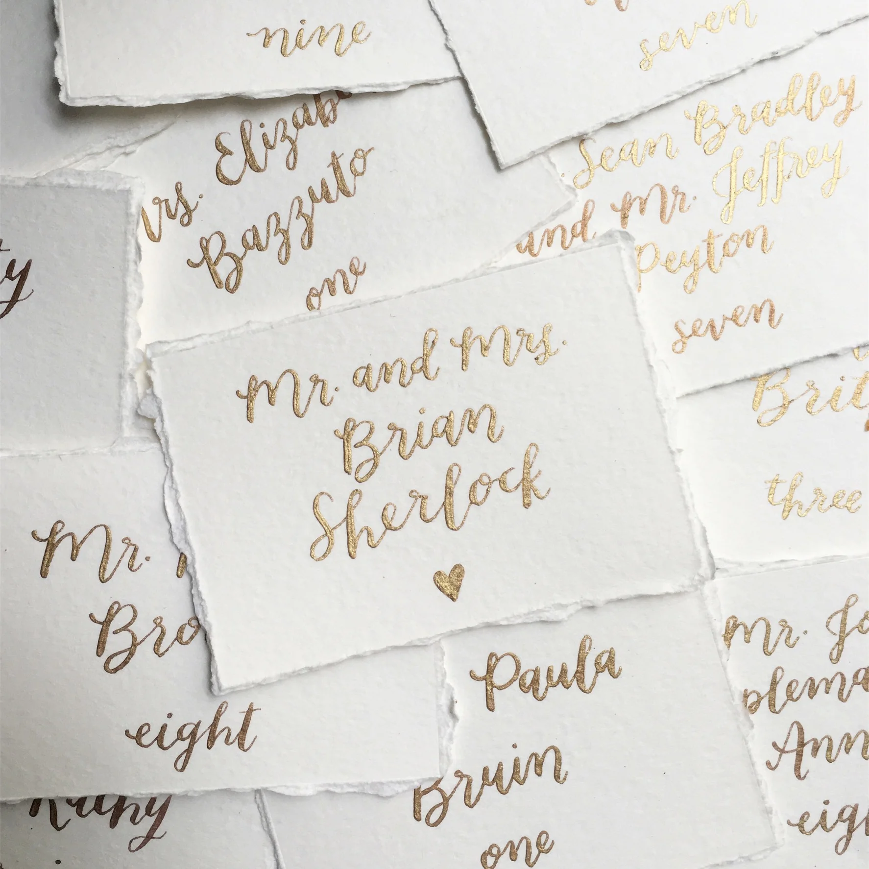  gold ink calligraphy escort cards by hello bird // shown with deckle edges 