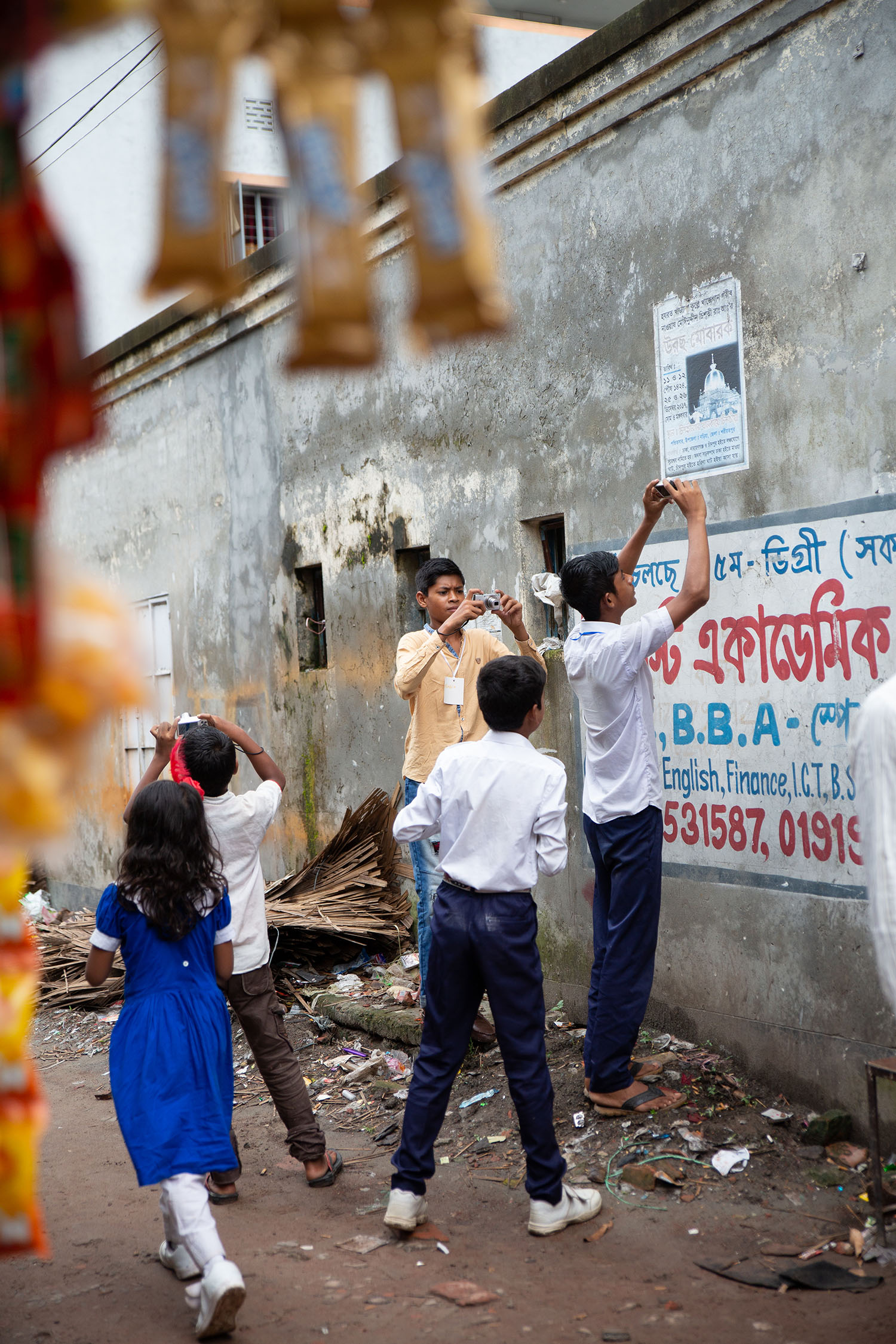 Students taking pictures for the Lesson 1 scavenger hunt, Nuru Chala neighborhood of Dhaka.
