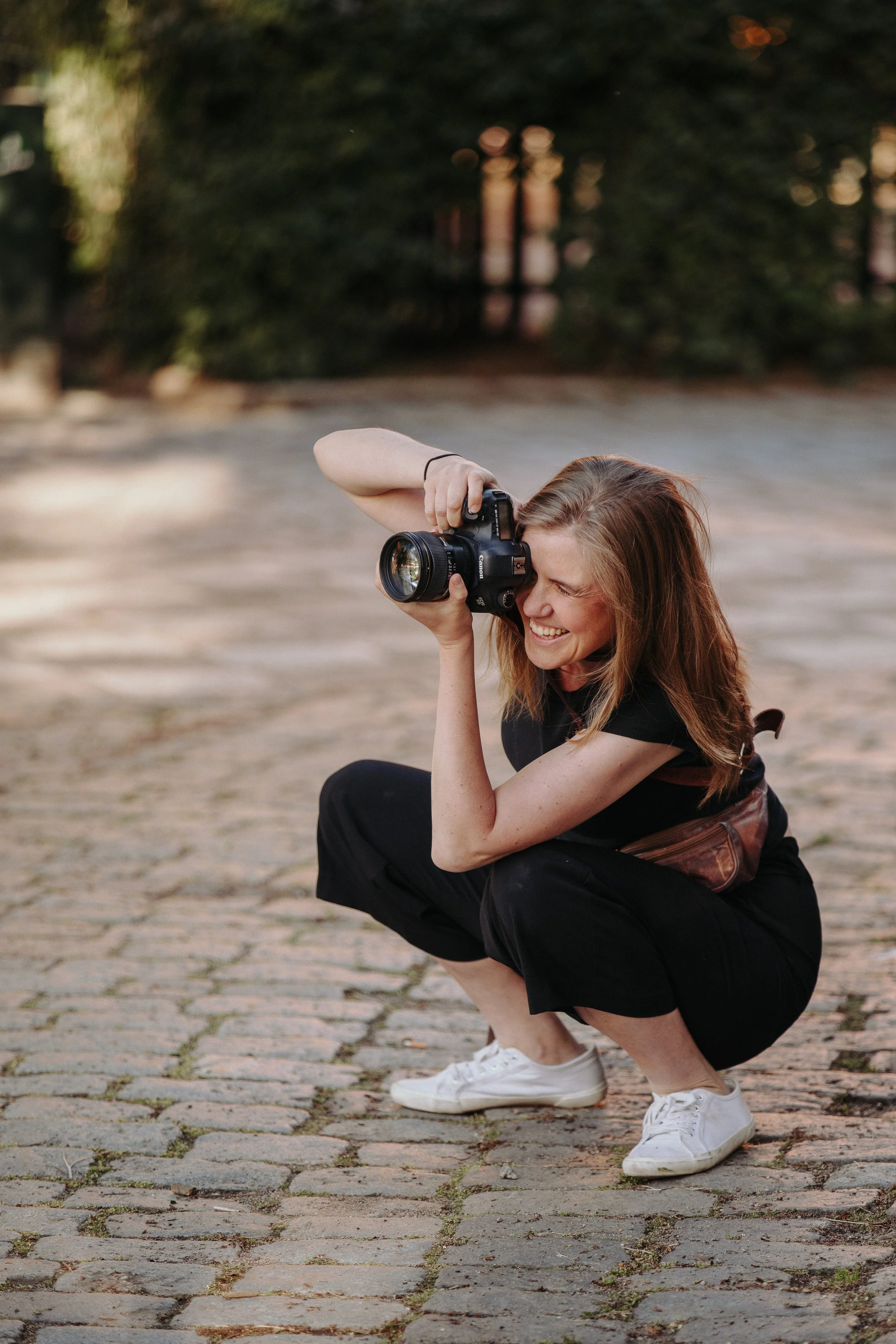 Sara Lejon, fotograf i Ystad, med kamera på stenlagd gata