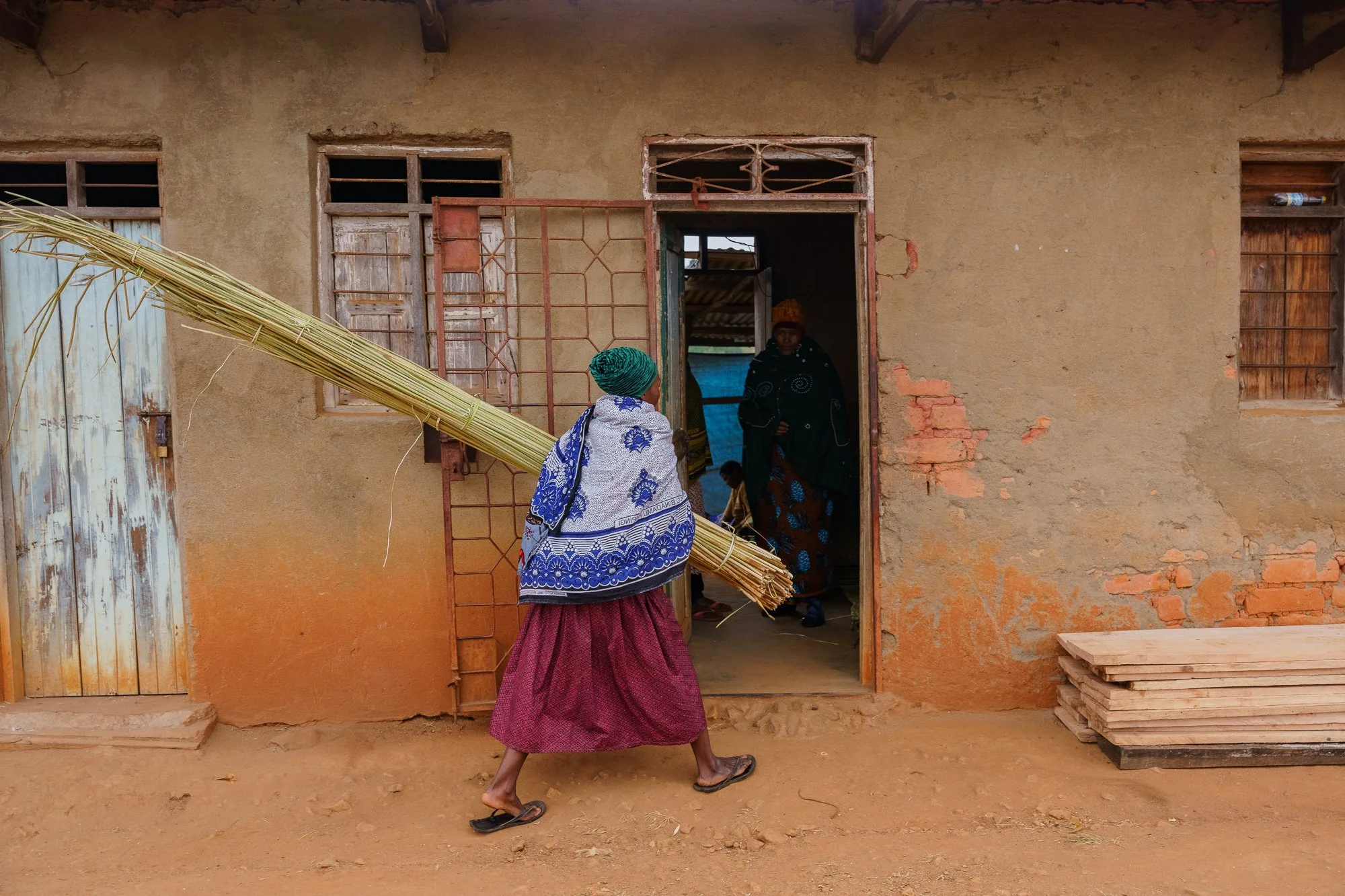  Members of the Mengwa Women Group get raw materials used to make mats and store them inside their storage area, a room next to where they work. 