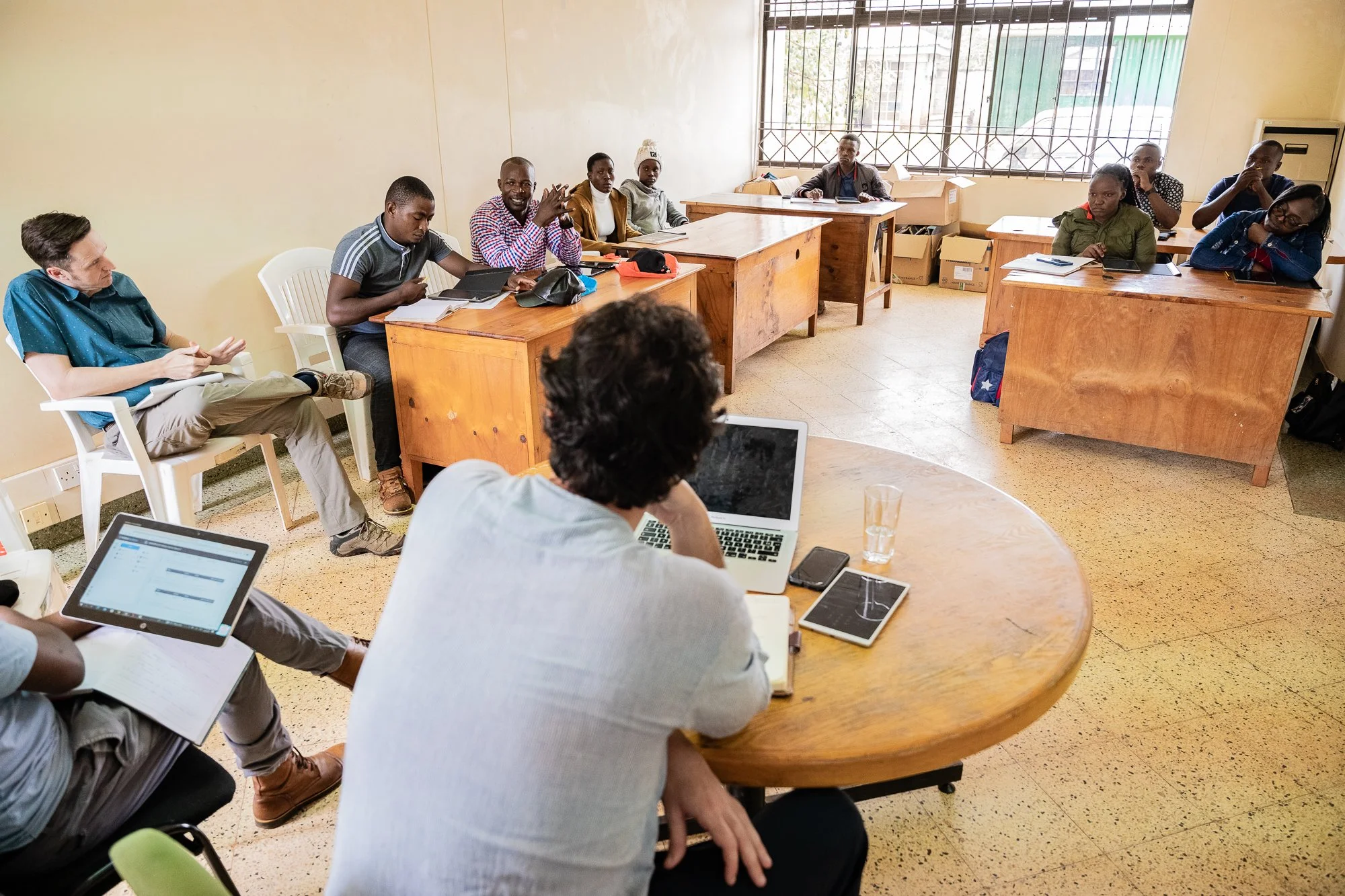 AKFC International Youth Fellowship fellow guiding youth fellows through learning materials during a workshop session in Kenya.
