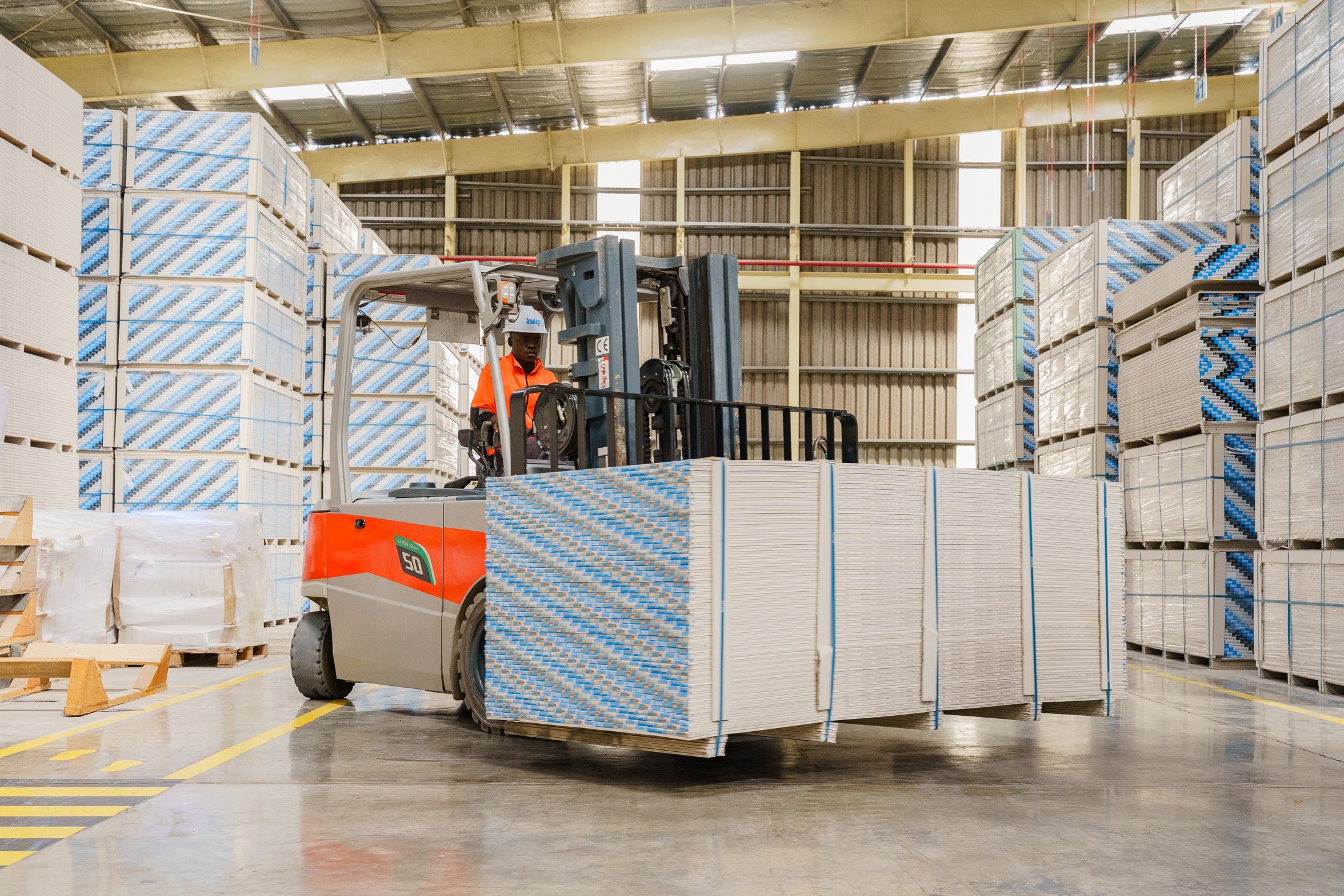 Manufacturing facility interior showing stacked building materials and industrial handling equipment in Mkuranga, Pwani Region, Tanzania