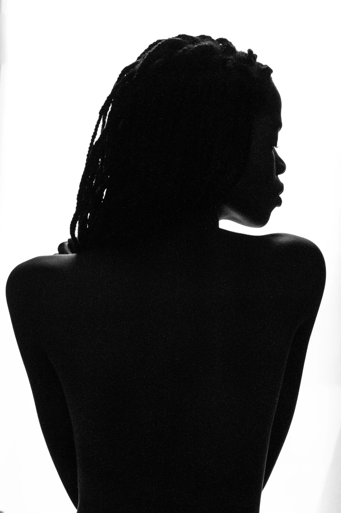 Silhouette of a woman with braided hair, facing right, against a white background.