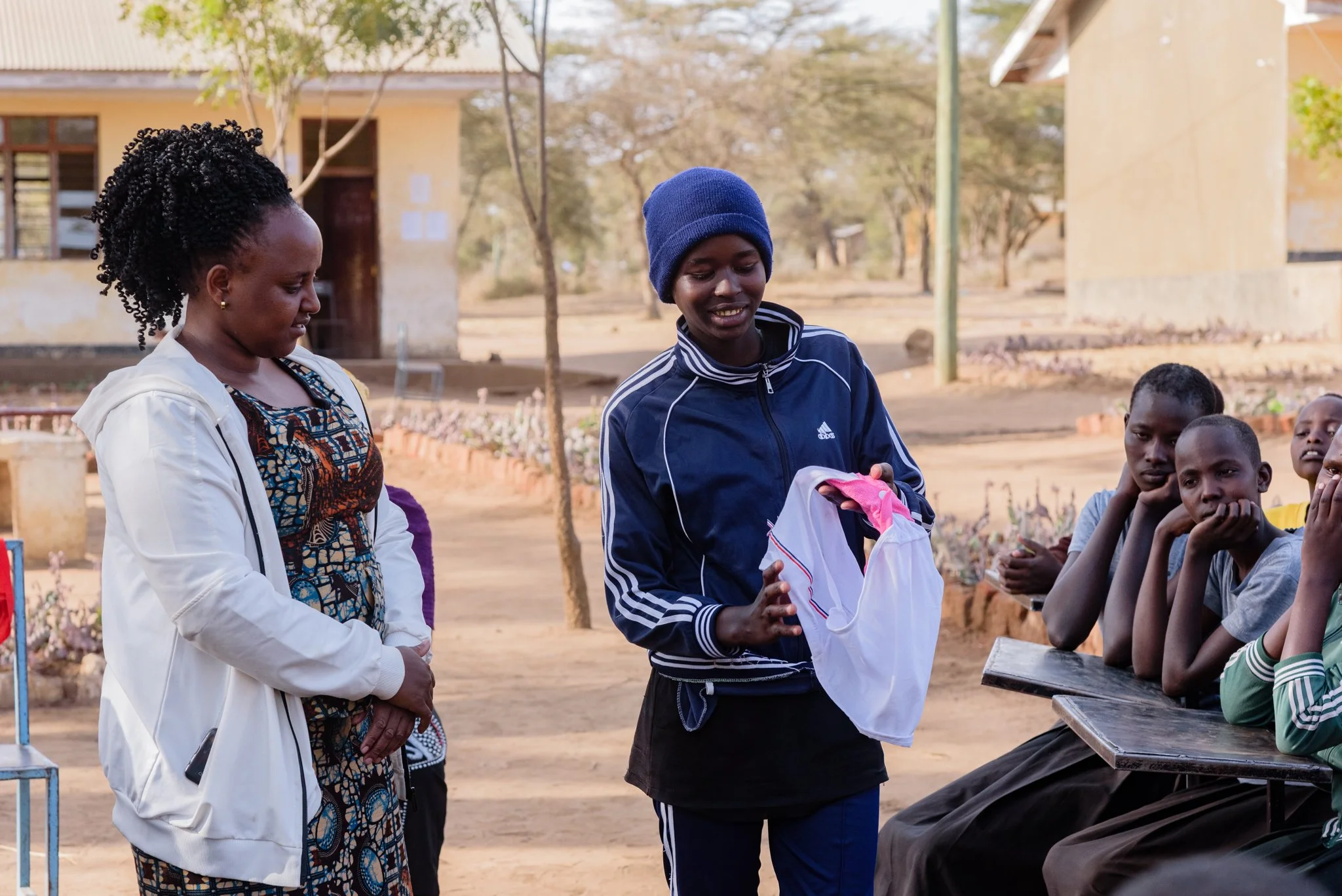 Malala Fund Education Champion observing a student demonstrate using a reusable sanitary pad to other Tanzanian students in Arusha, Tanzania.