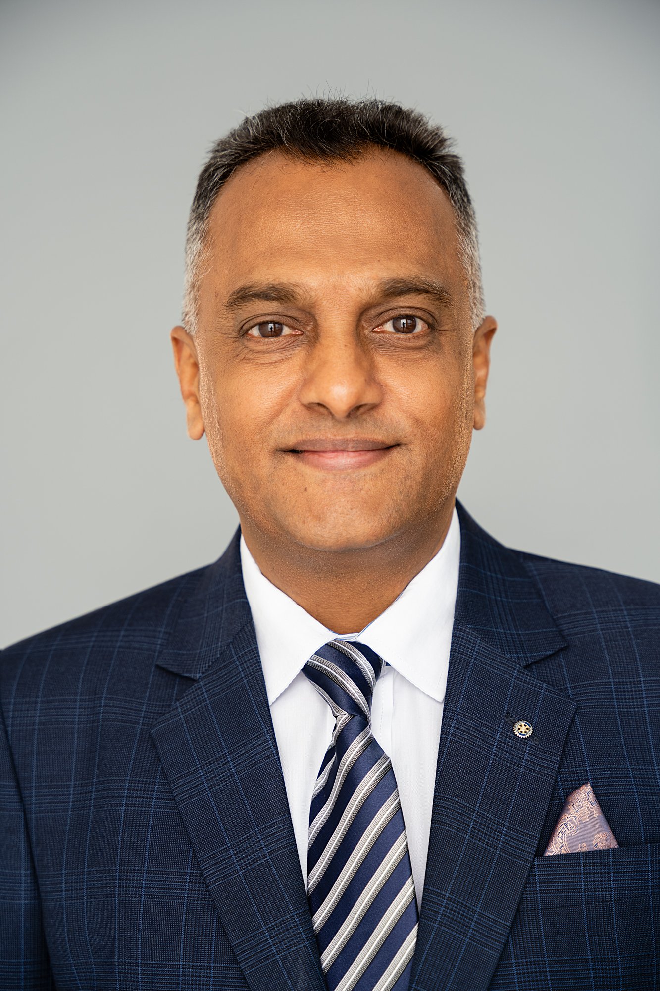 Professional corporate headshot of a man against a plain grey background in Dar es Salaam, Tanzania.
