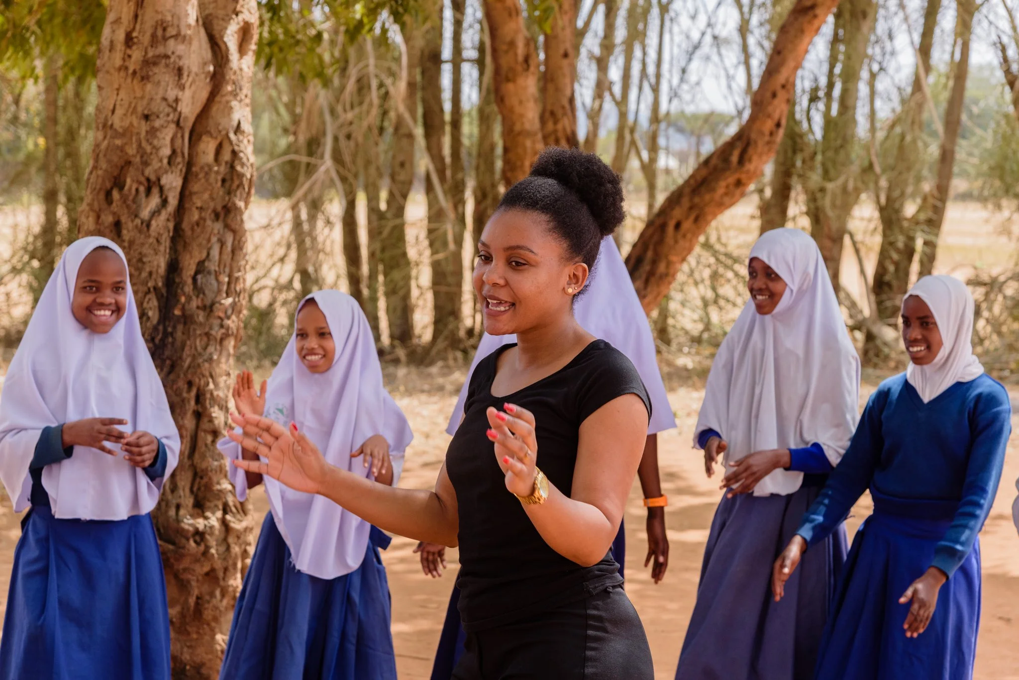Malala Fund Education Champion leading Tanzanian schoolgirls in an outdoor dance in Dodoma, Tanzania.
