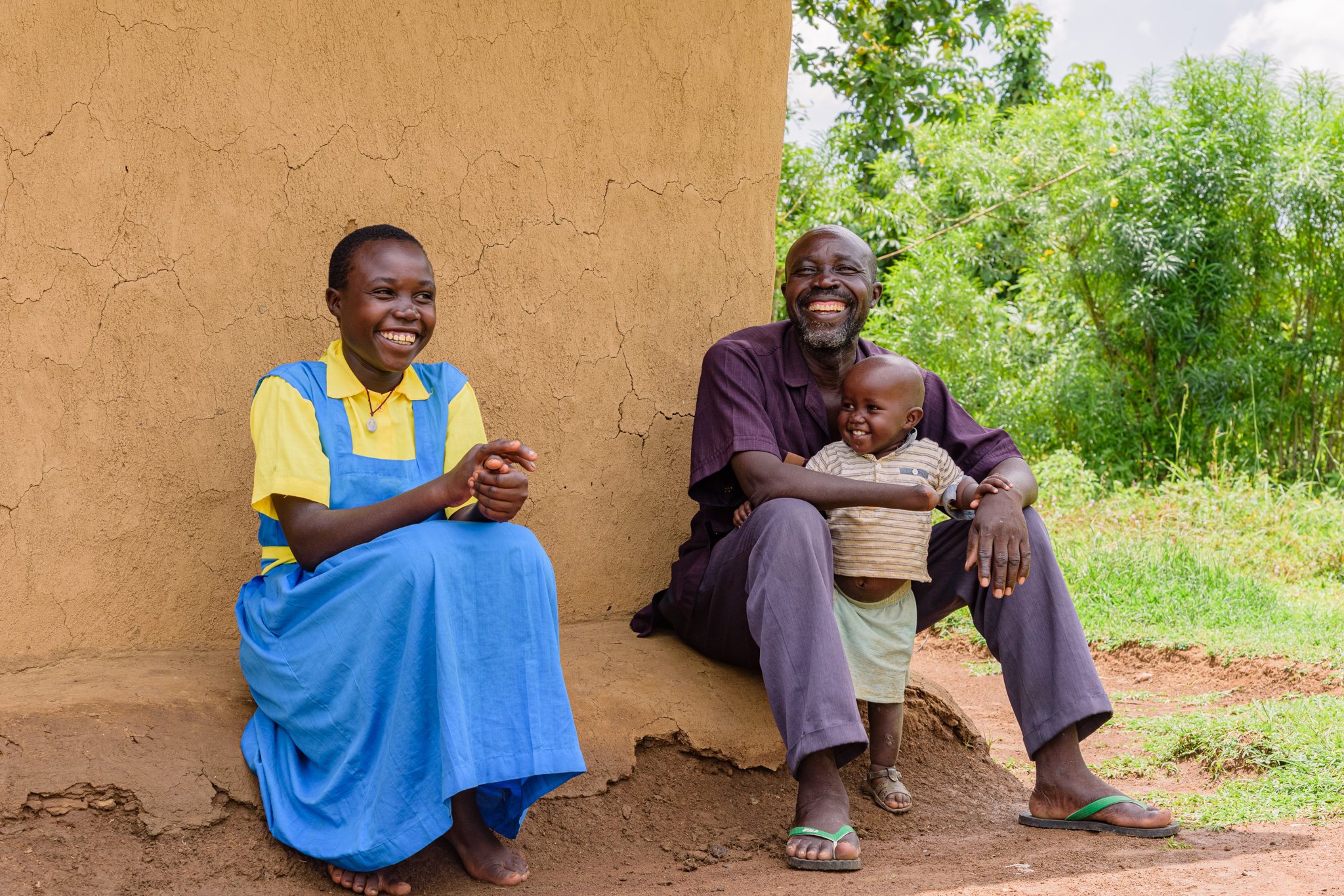 Family members sitting outside their home in Kenya, reflecting community engagement within Leonard Cheshire’s inclusive education programme.