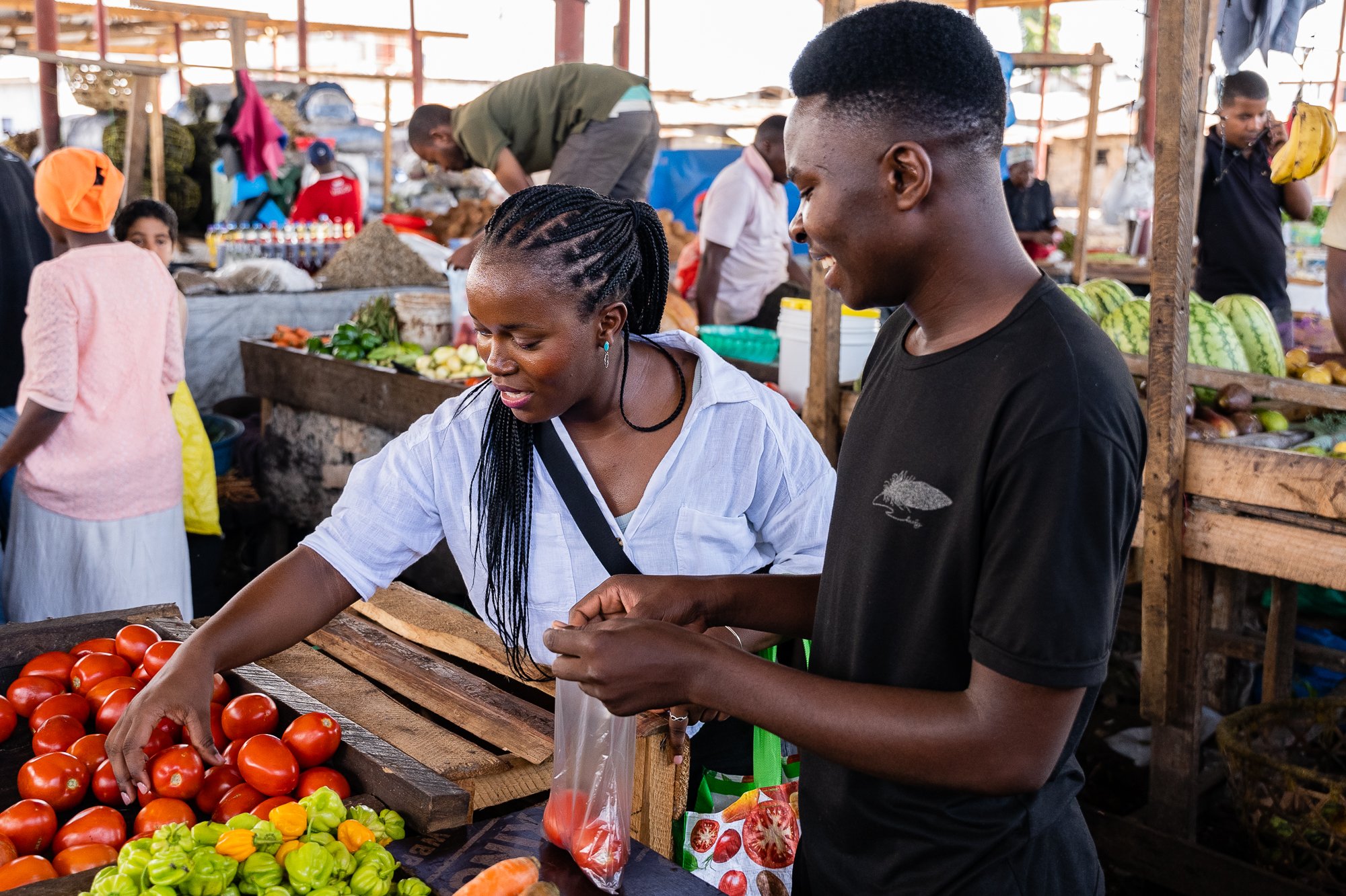 AKFC International Youth Fellowship participants interacting with local vendors during a community market visit in Dar es Salaam, Tanzania.