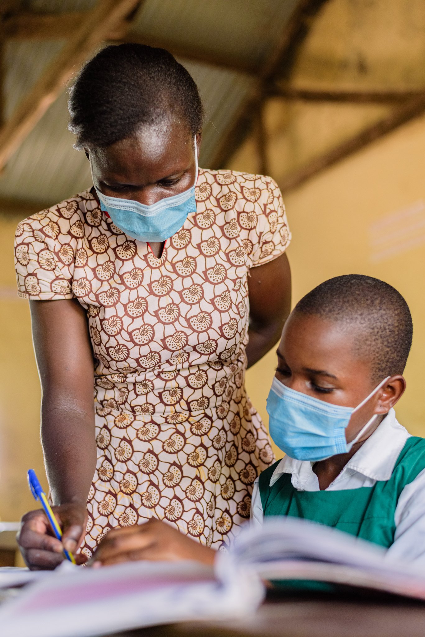 Teacher assisting a student during a classroom lesson in Kenya. Image captured during Leonard Cheshire’s inclusive education initiative.