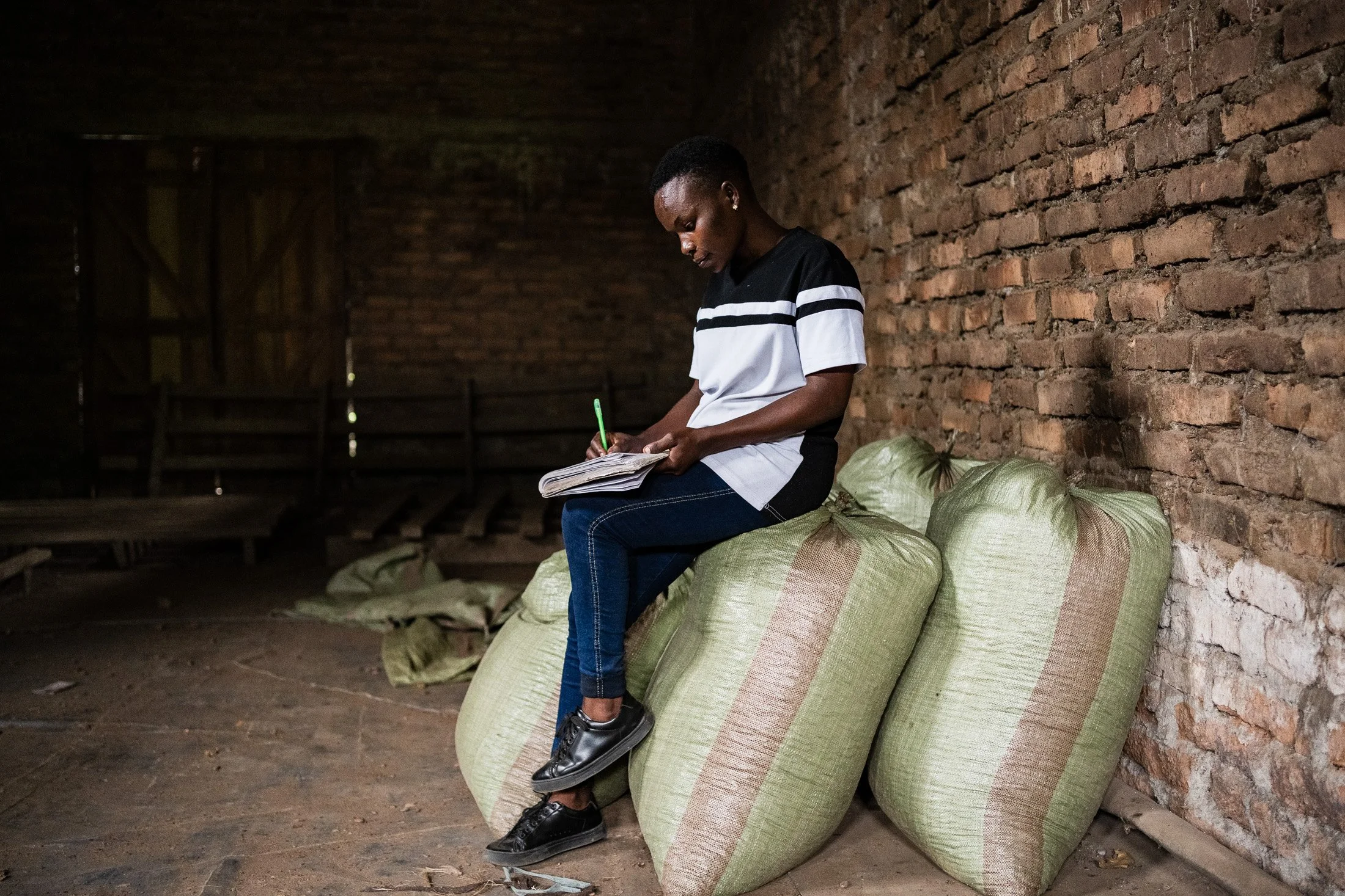 Clerk recording cocoa production data as part of accountability practices in Kyela, Tanzania.
