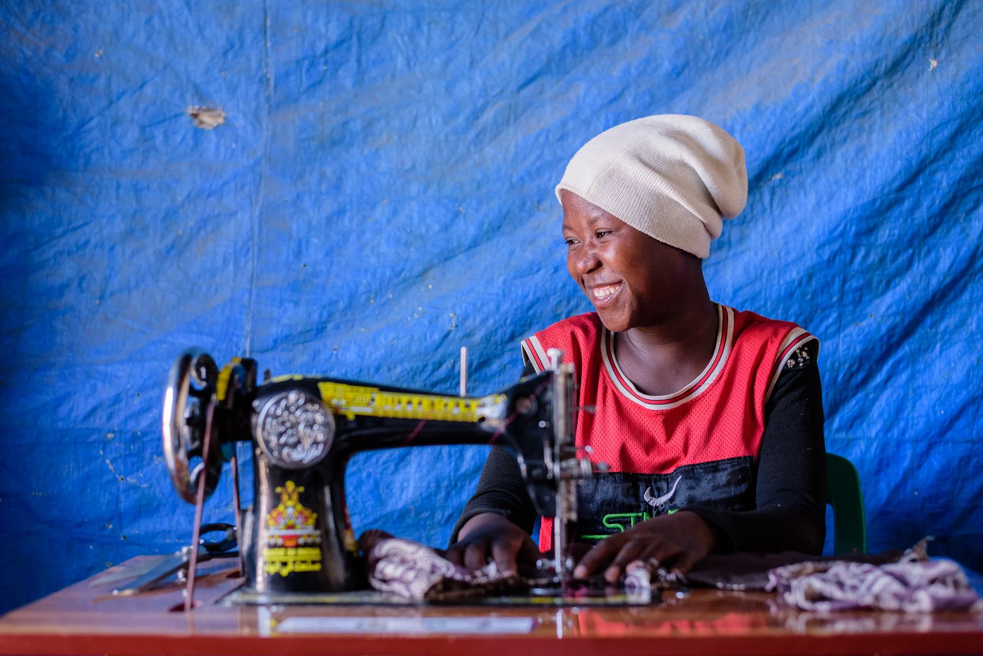 Woman uses a sewing machine inside a small workshop in Mbeya, Tanzania.