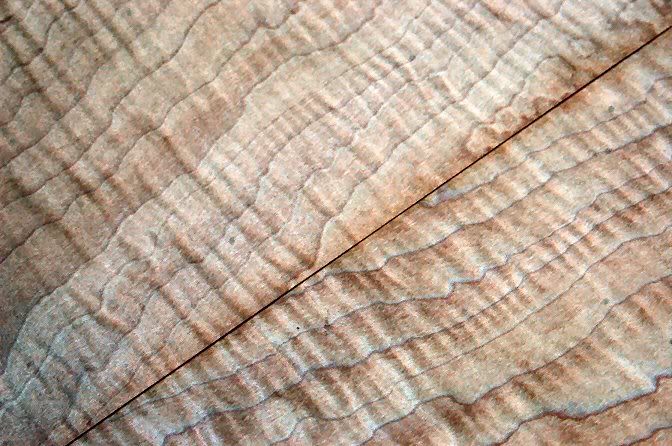 Adjust the veneer until you have a good pattern to the grain, and mark where the trim must be.
