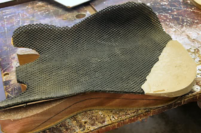 My choice, apply a couple of pads I cut from “Non Slip” work table pads. You will notice the “block” I have made to take up the void left by the curve of the contour. To make it, I took a body, put down a sheet of plastic and filled it in with Auto Body Putty, let it harden and shaped it so the top would be flat with the pads. The pads are about ½" thick so they take up any inaccuracy as the filler block is used with other bodies.