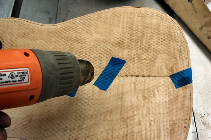 It’s pretty ugly at this point, but take a heat gun, hair dryer, or whatever to soften the well stuck tape and remove it. The heat allows the adhesive to release without pulling fibers or worse, chunks out of the veneer.