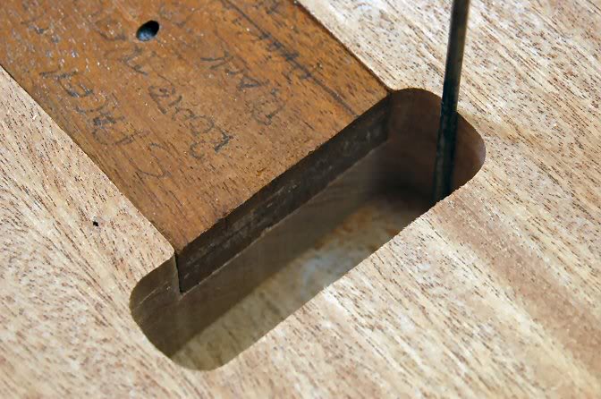 First thing I do is drive an awl through the tremolo cavity on both edges to indicate the location of the bottom rout. This way I can be certain the top rout will be correctly centered. It’s not impossible to be off by a 32nd or so, and while that isn’t a factor, it does drive me nuts.