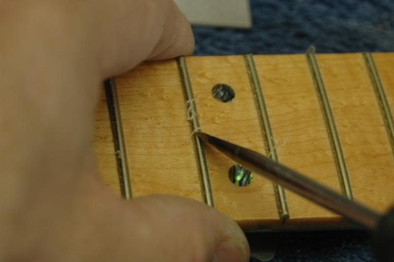  Once the majority is removed, I go back gently scraping each edge of the fret.&nbsp;I don’t have to be NASA clean room certified here, the fret leveling, and polishing will remove the remaining residue. Some will not remove the lacquer at all, but a